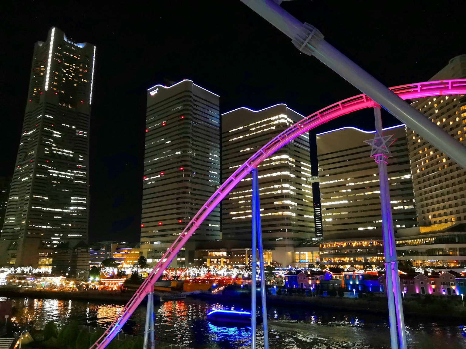 ทิวทัศน์ยามค่ำคืนของเส้นขอบฟ้ายอกาฮามะพร้อมโค้งรถไฟเหาะสีสันสดใส