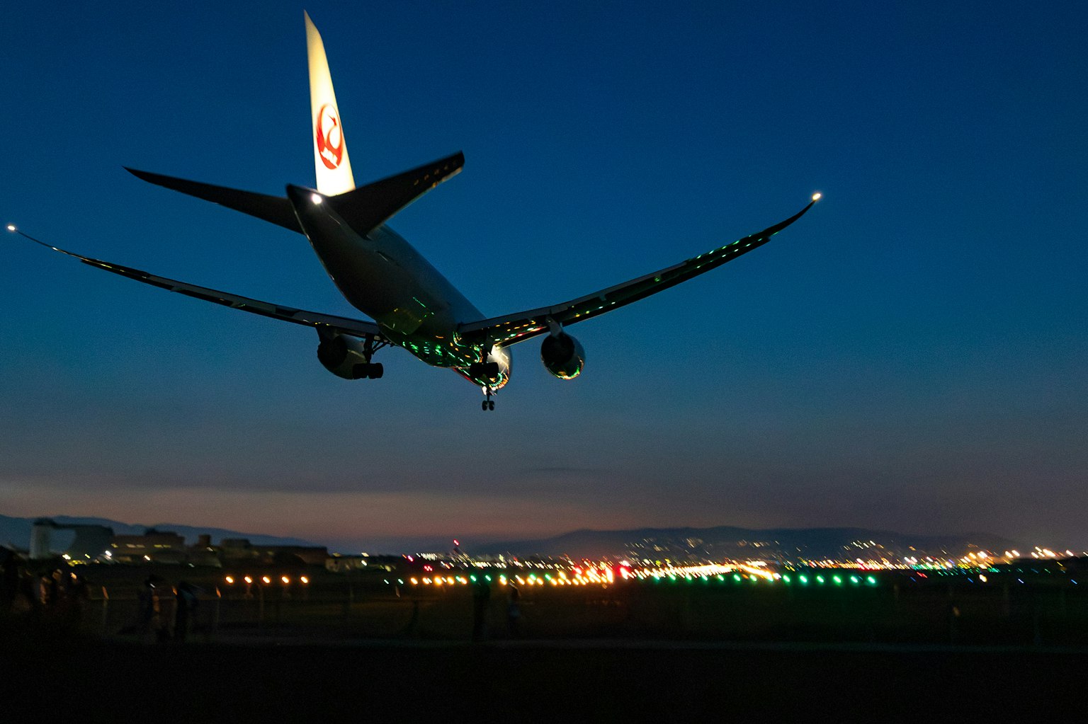 夜空に飛行機が着陸する様子 航空機の翼に緑色のライトが点灯