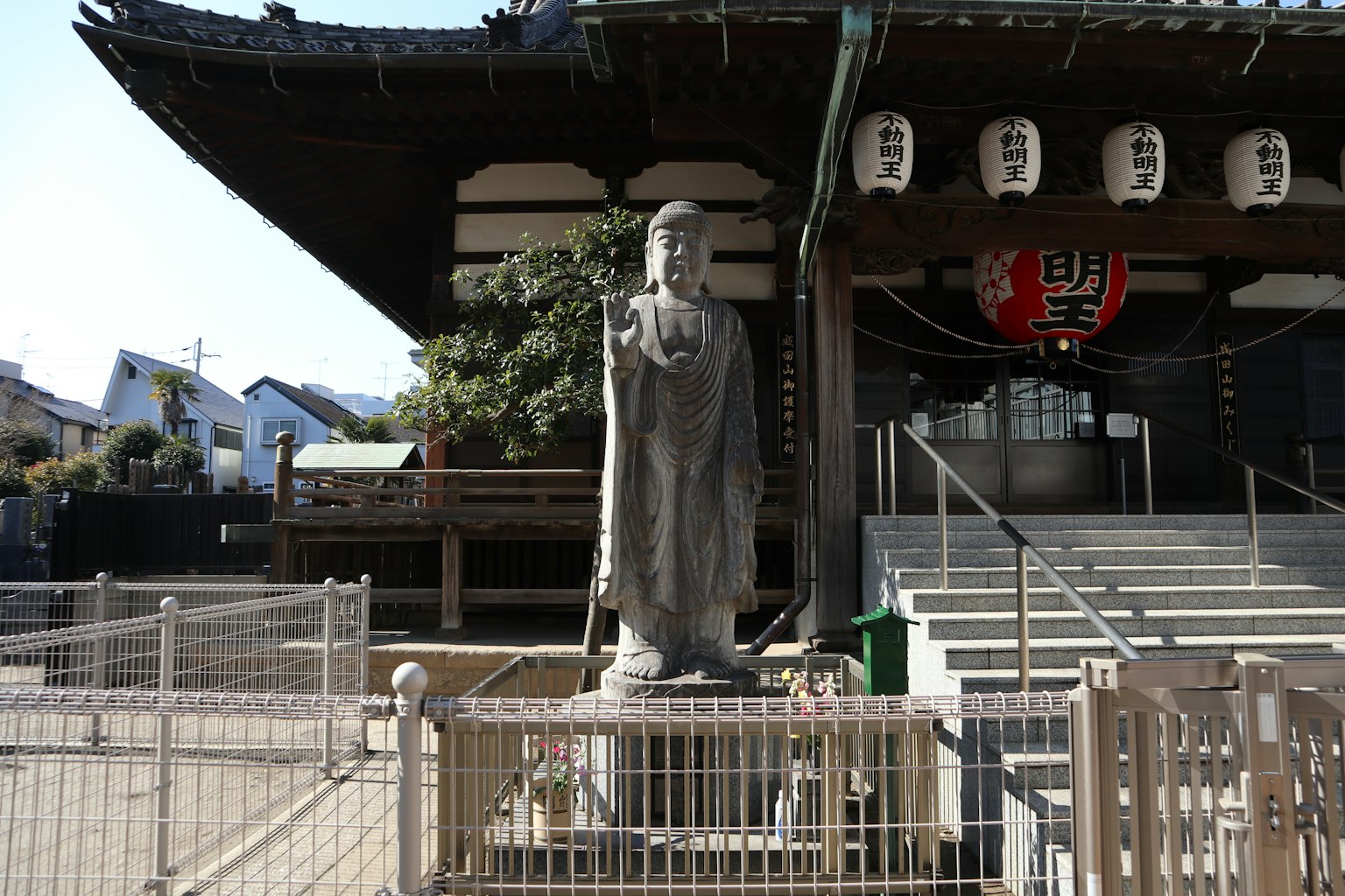 Traditional Japanese temple scene with a statue in front