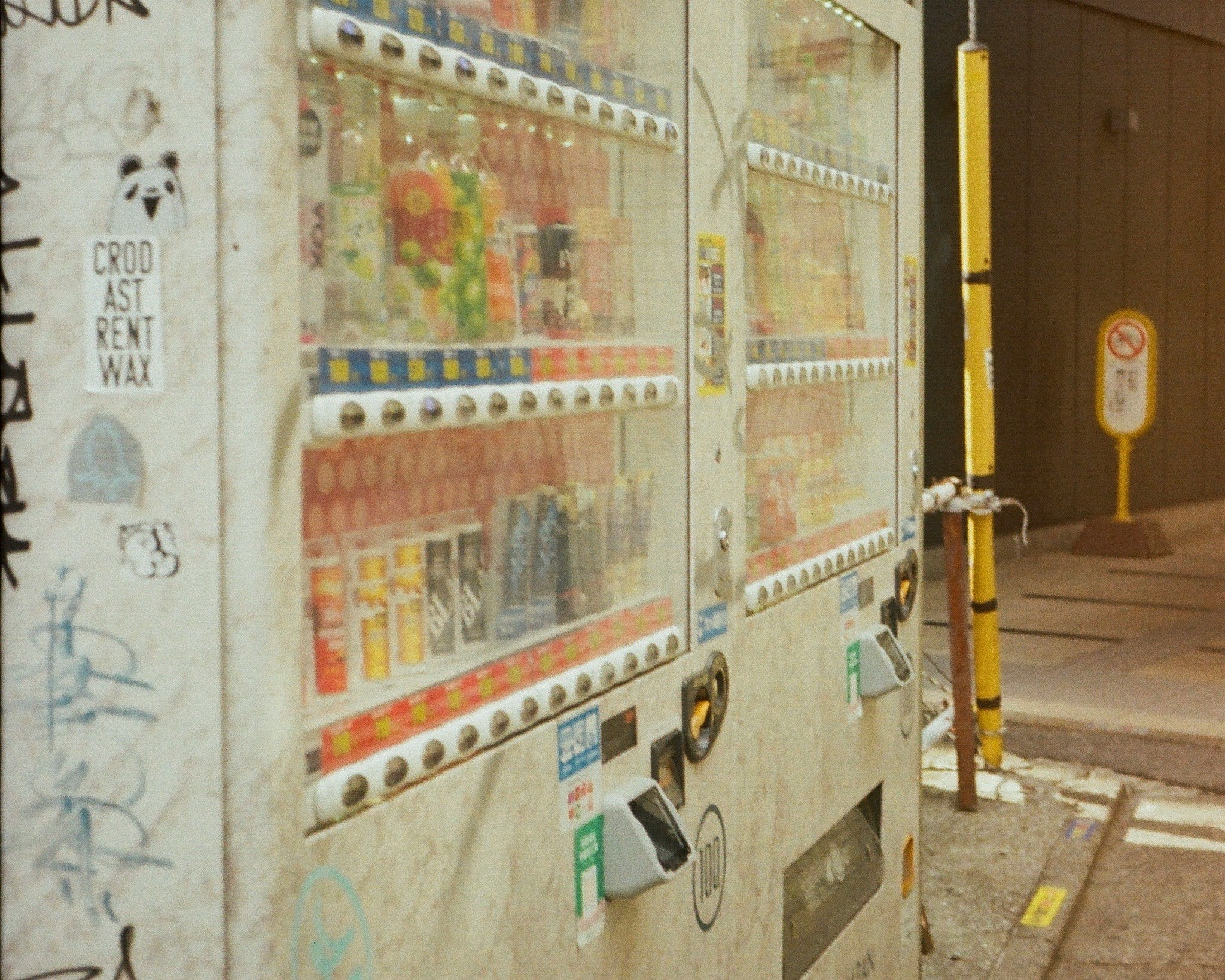 壁に並ぶ古い自販機と落書きのある路地