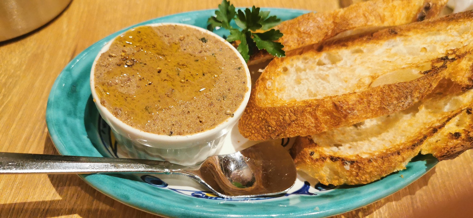 Pâte crémeuse servie avec des toasts et du persil