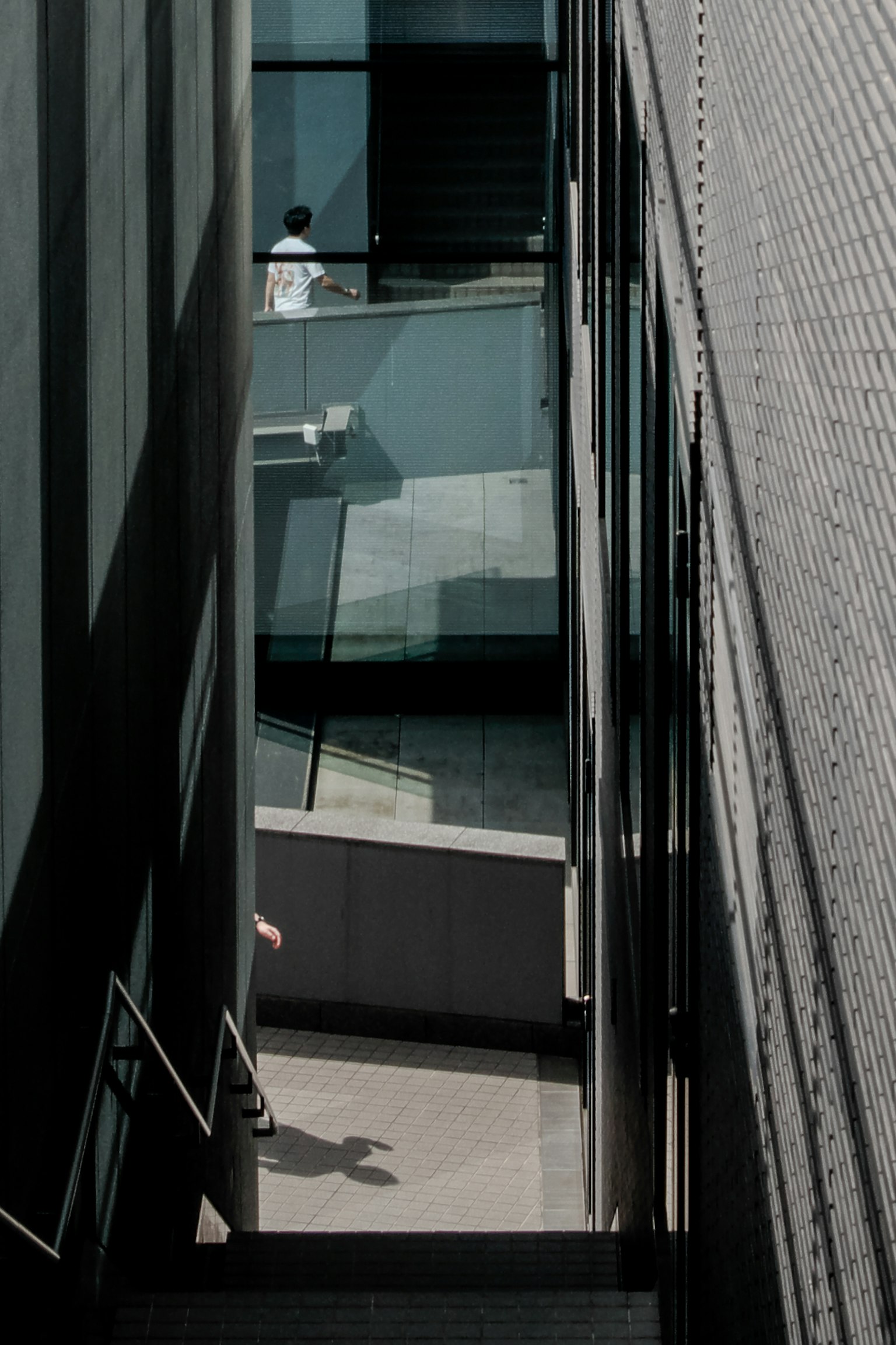 Pasaje estrecho entre edificios modernos con una persona caminando