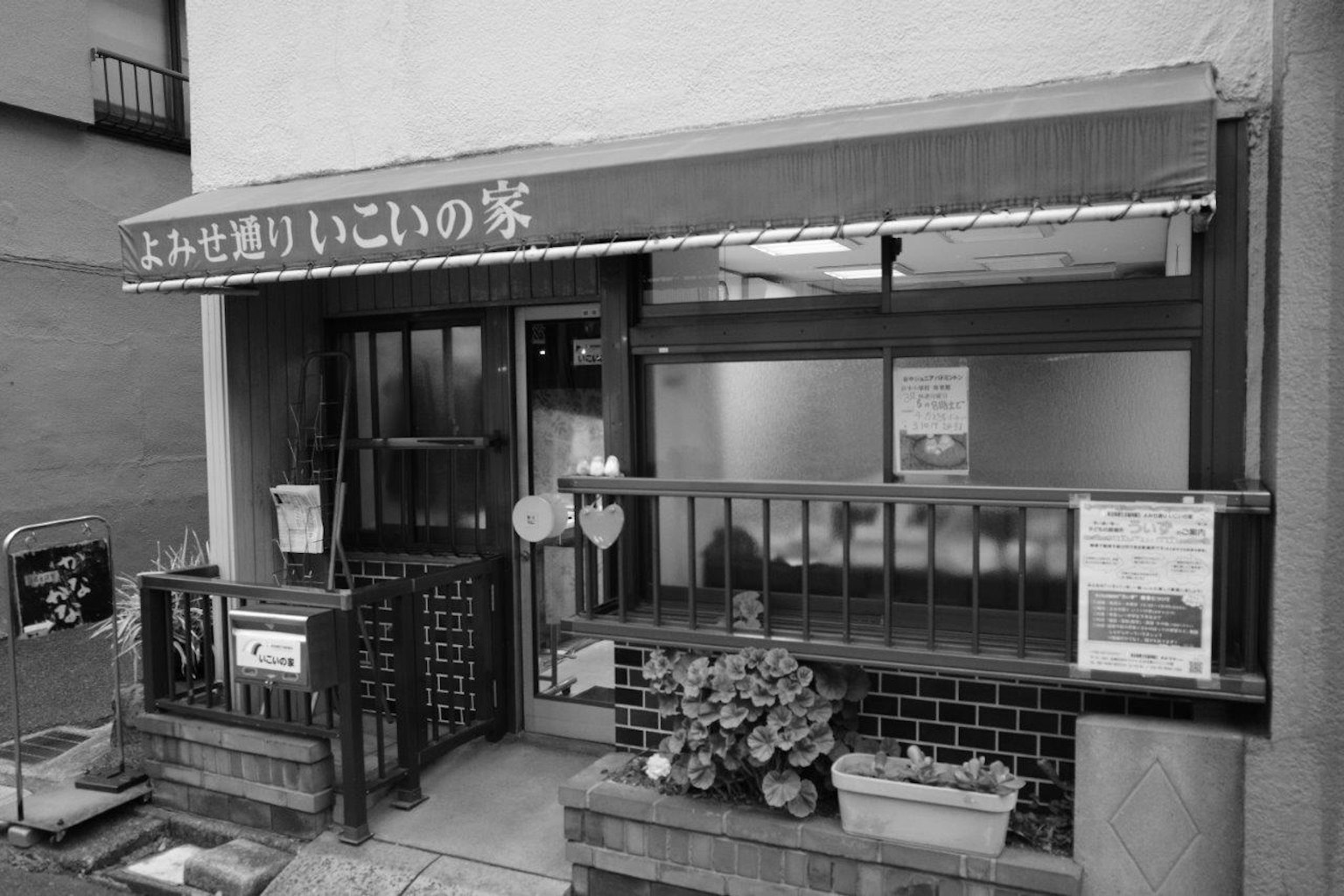 Entrée d'un petit restaurant japonais avec une façade en noir et blanc