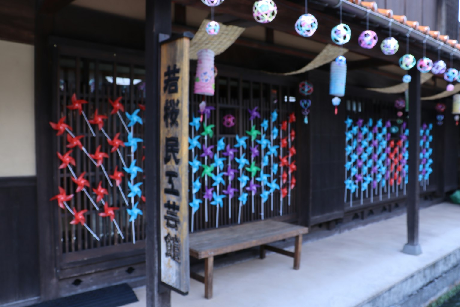 Exterior de un edificio japonés tradicional con decoraciones coloridas en las ventanas y un letrero