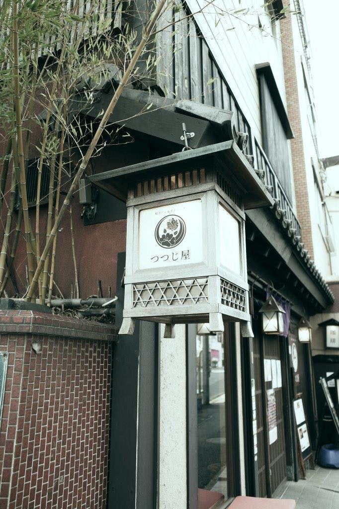 竹垣と路地の軒先に下がる看板のある街並み