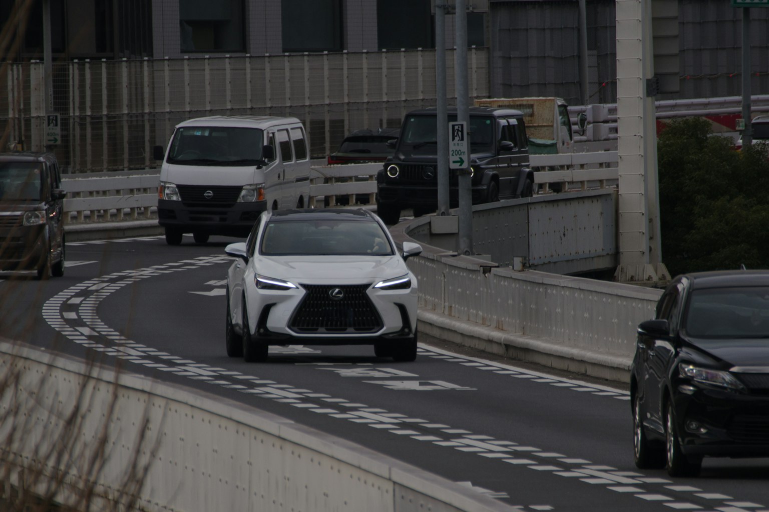 SUV bianco che percorre una strada tortuosa con veicoli circostanti