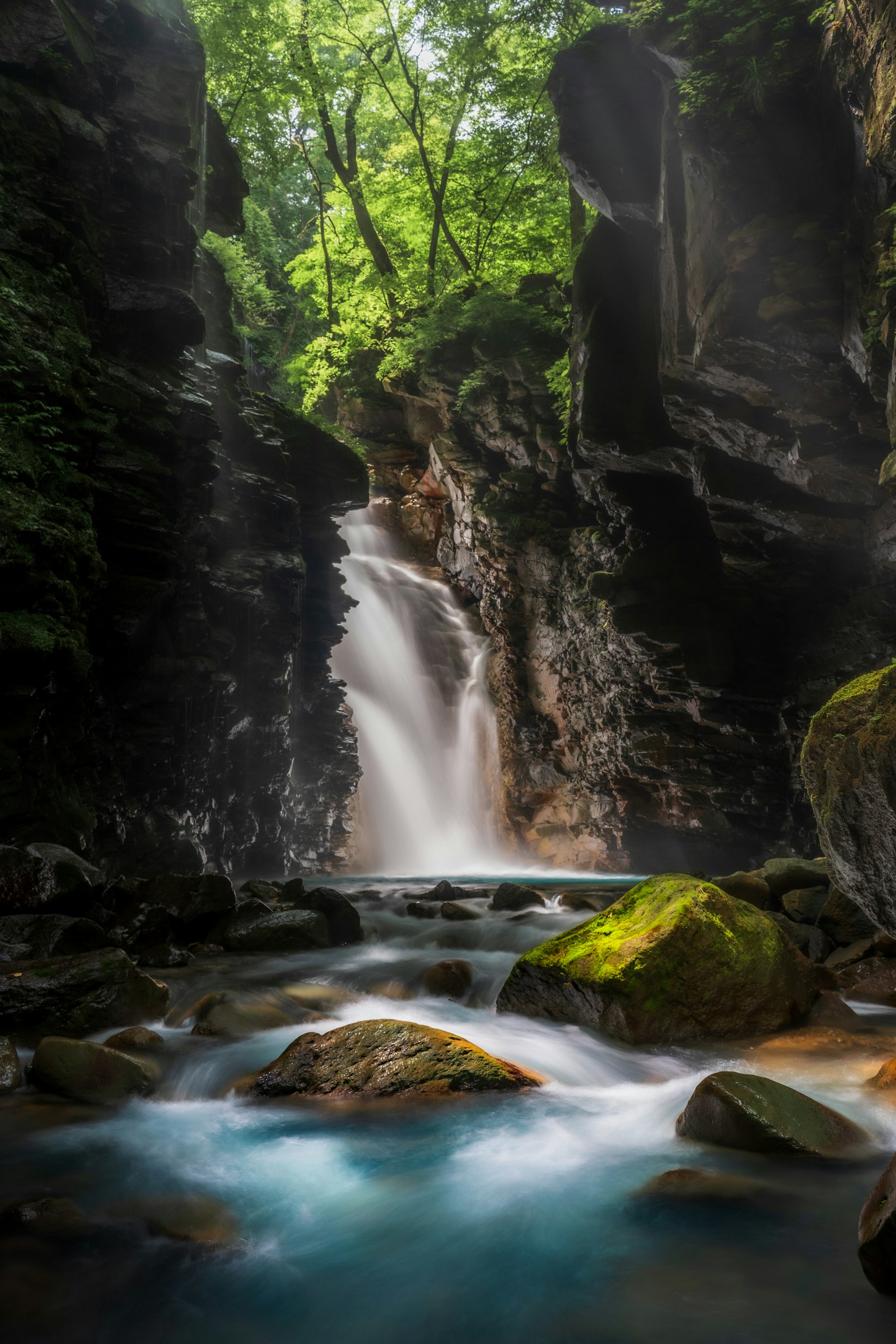 A serene waterfall surrounded by lush greenery and smooth flowing water