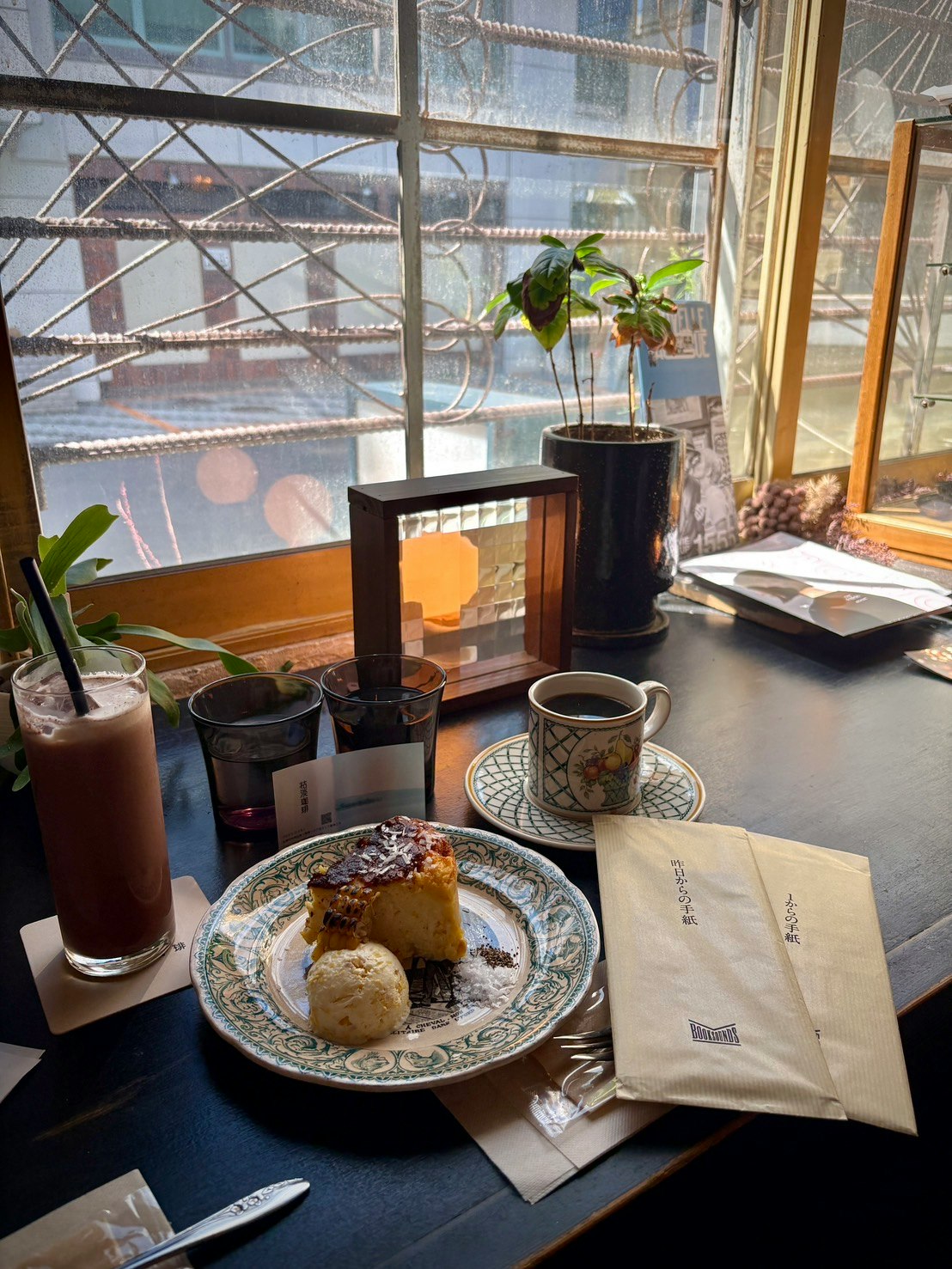 窓辺のカフェテーブルに並ぶコーヒーとパン