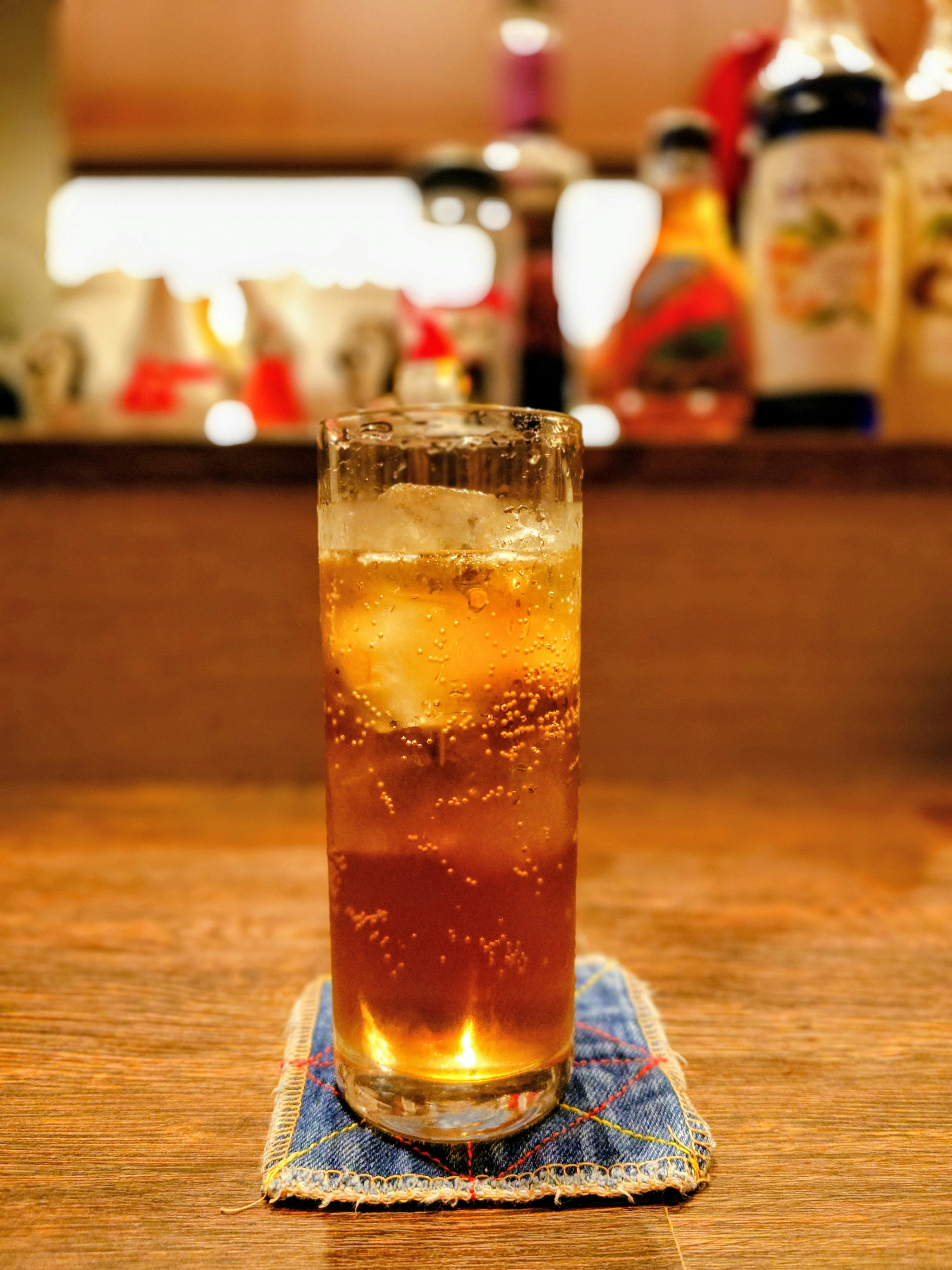 ノンアルコールカクテルのグラスと氷の泡が立つバーのカウンター
