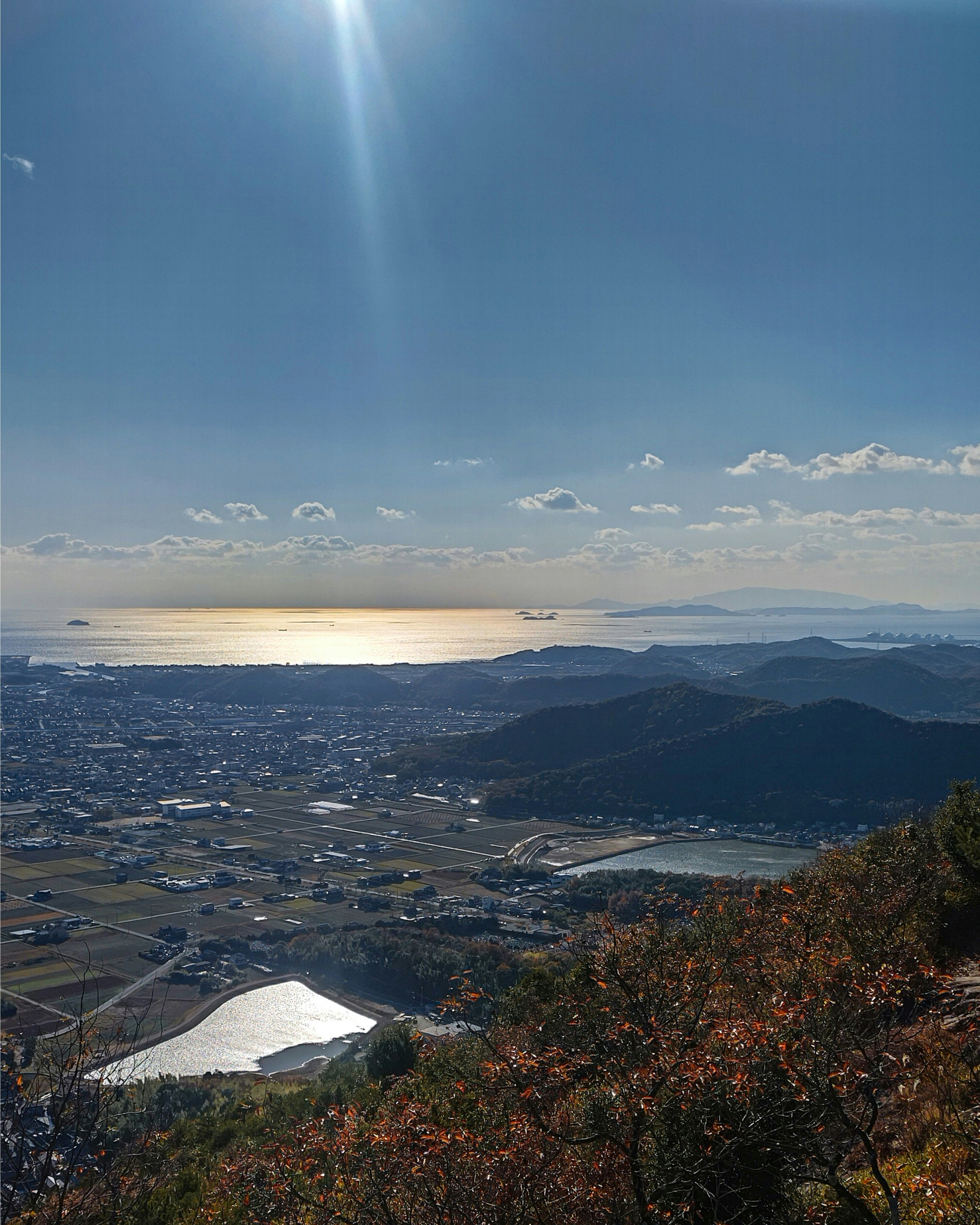 山の展望台から見下ろす海と街並みの夕景