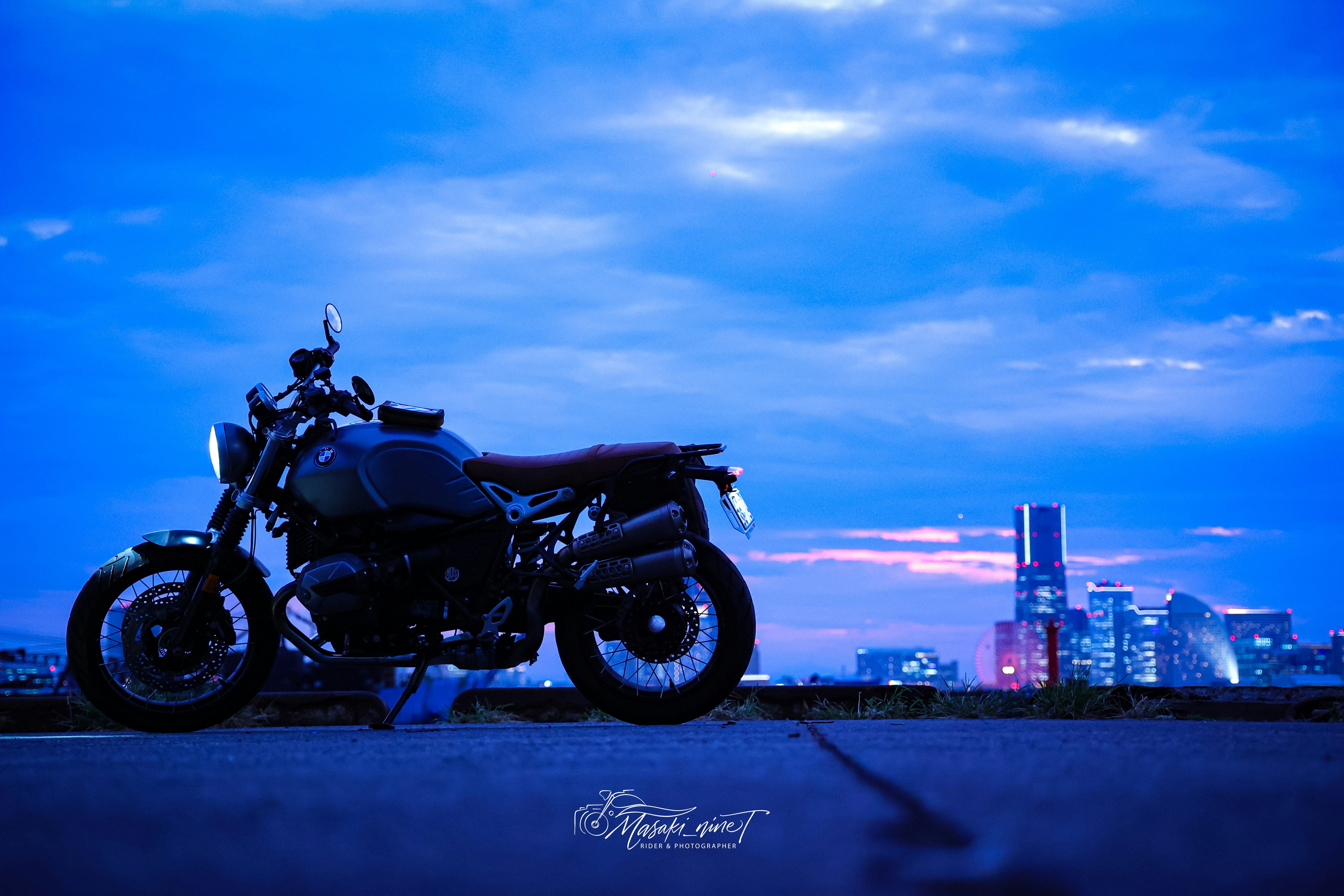 夜の街並みを背景にバイクが停まるシーン