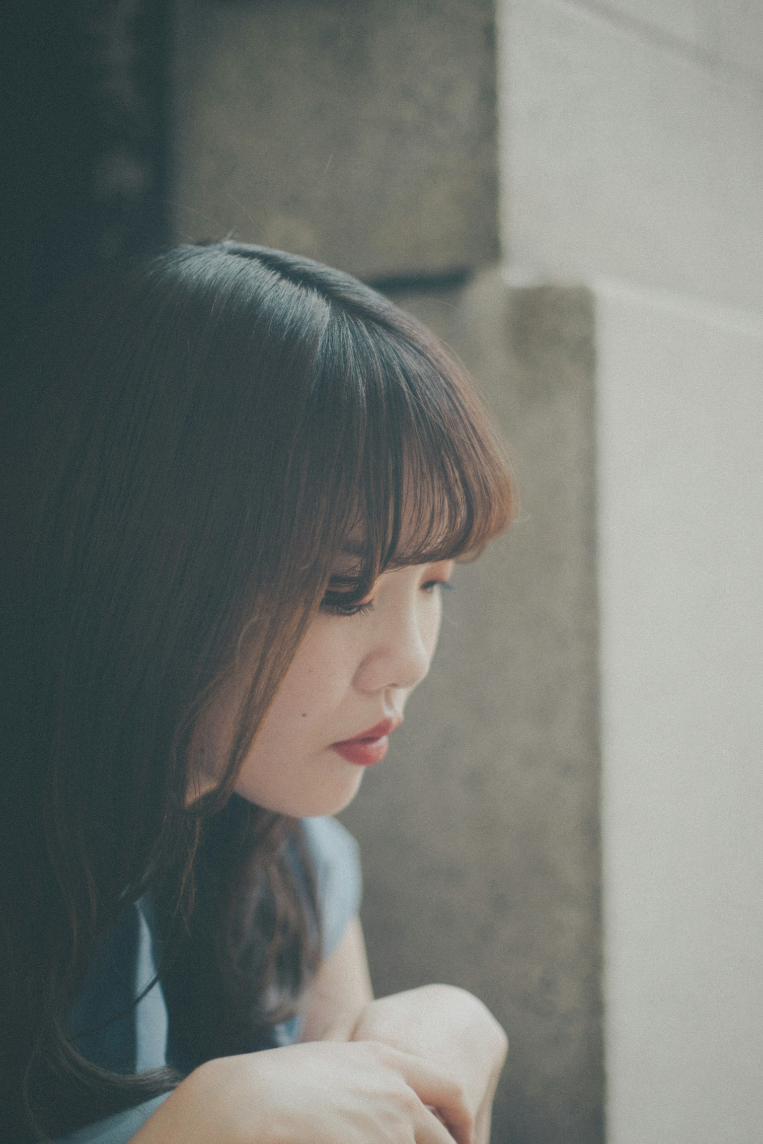 옆을 바라보는 젊은 여성의 모습 부드러운 조명이 얼굴을 비추며 평화로운 분위기를 연출
