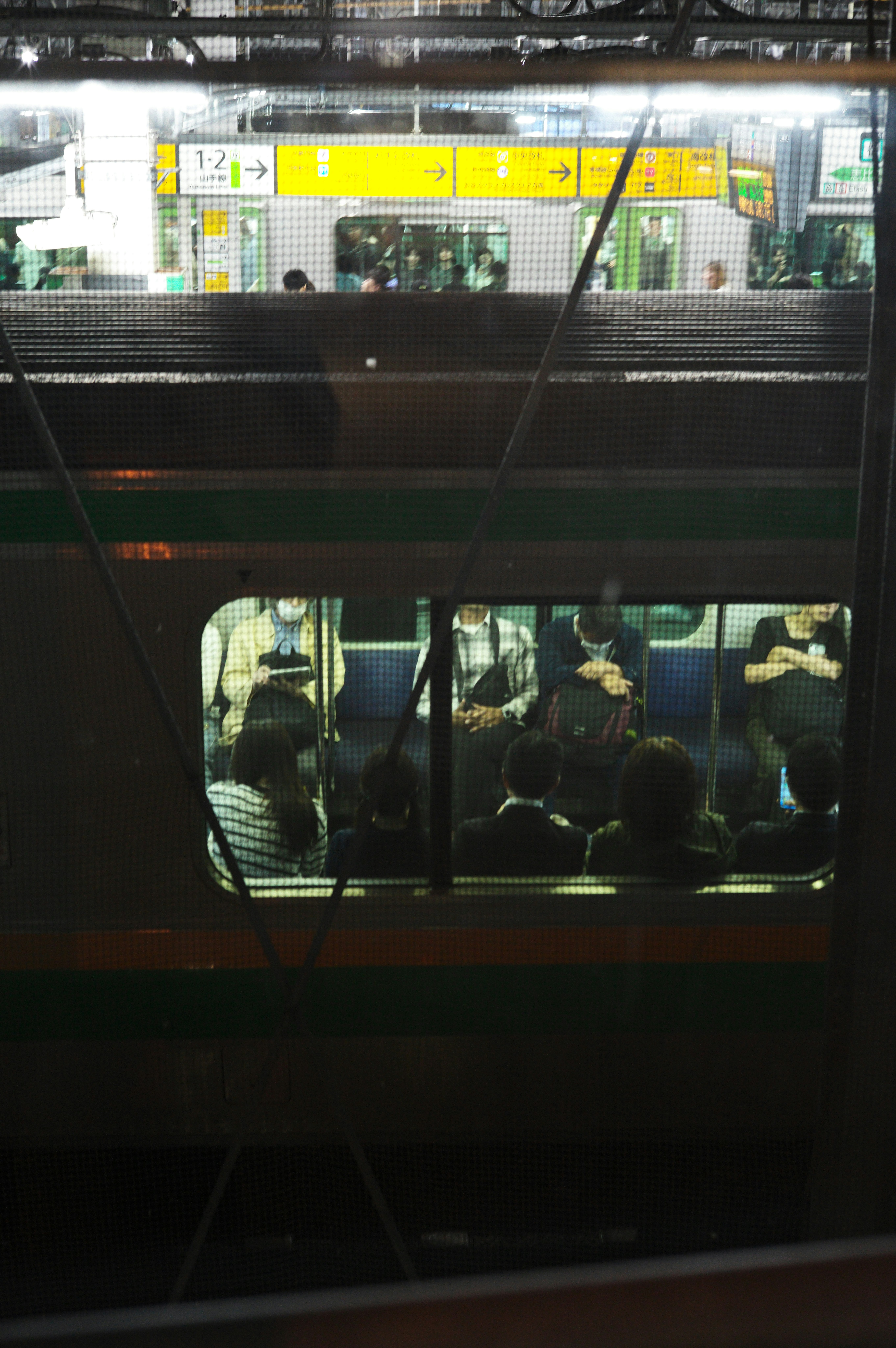 personnes vues depuis la fenêtre d’un train sur le quai de gare