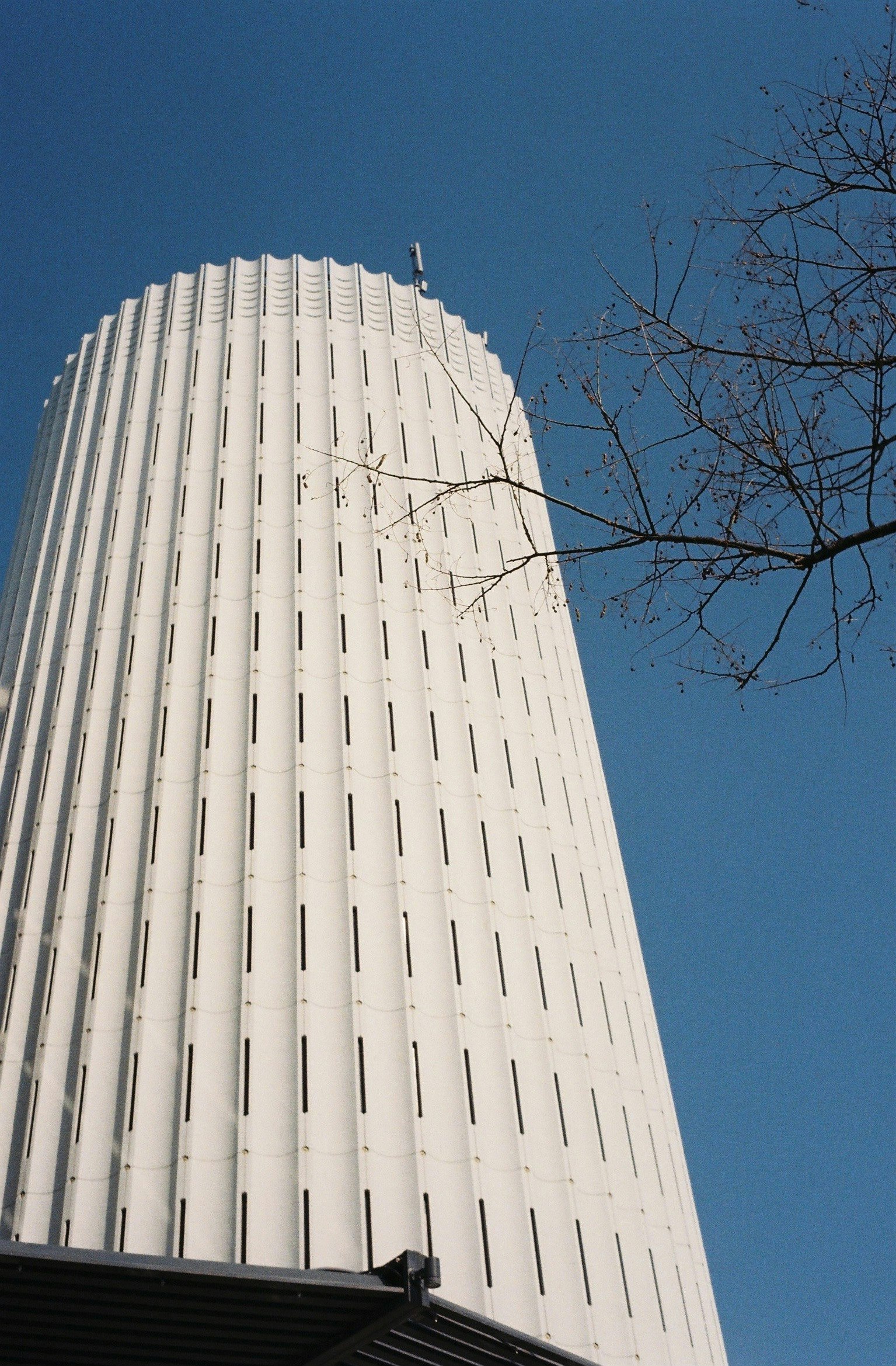 Exterior of a tall white skyscraper against a blue sky