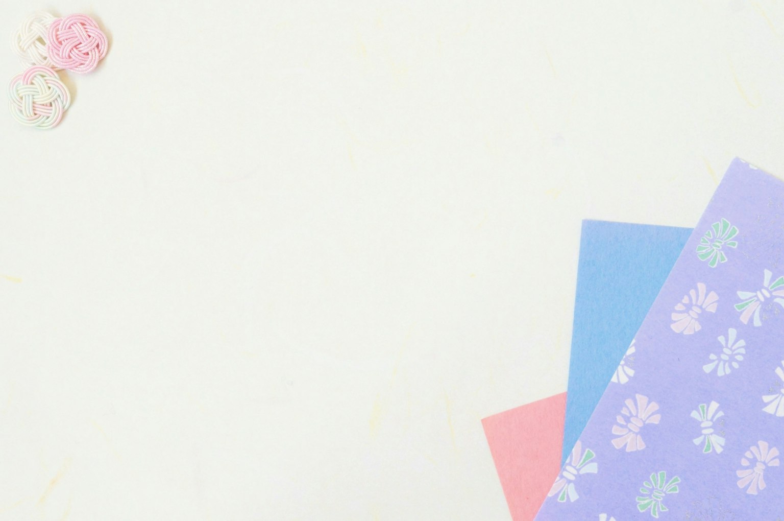 Heller Hintergrund mit buntem Papier und kleinen Blumen angeordnet