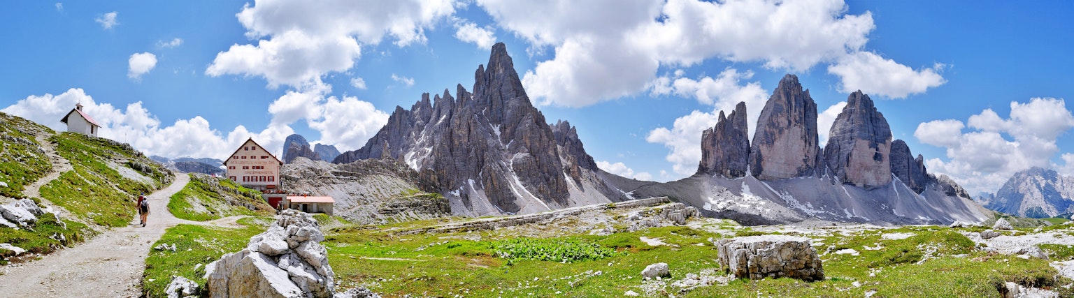Panoramablick auf die Dolomiten mit grünen Wiesen und blauem Himmel