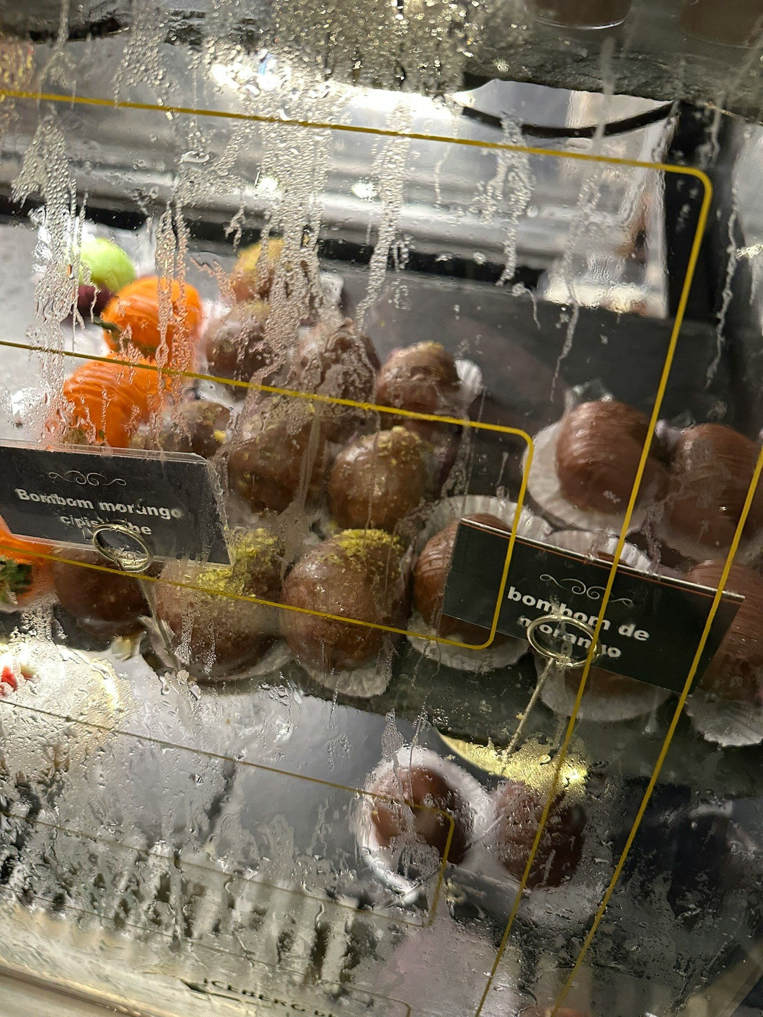 ガラス越しに並ぶ焼き菓子のドーナツとボンボローニ