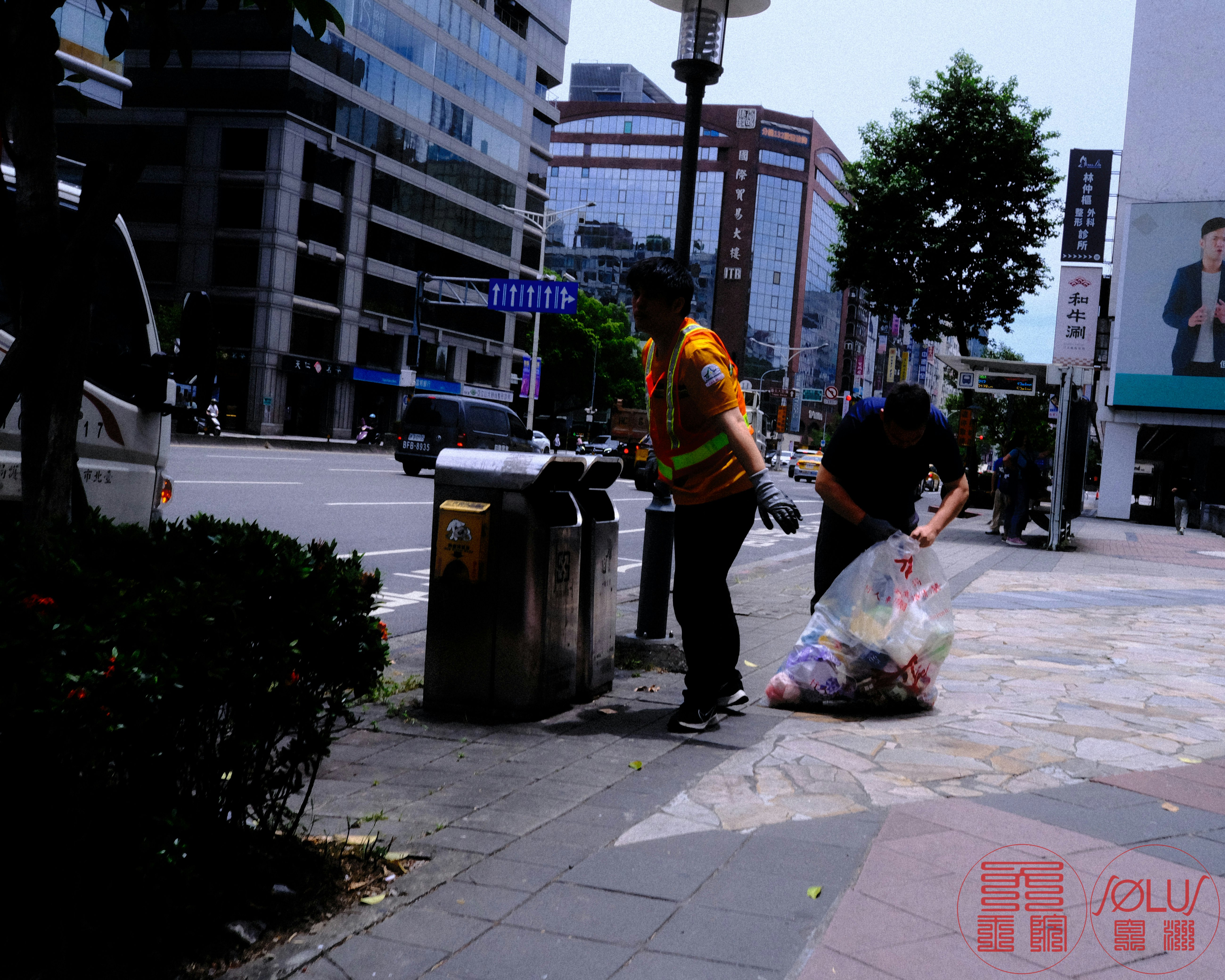 街路樹のある都市の歩道で買い物袋を持つ人