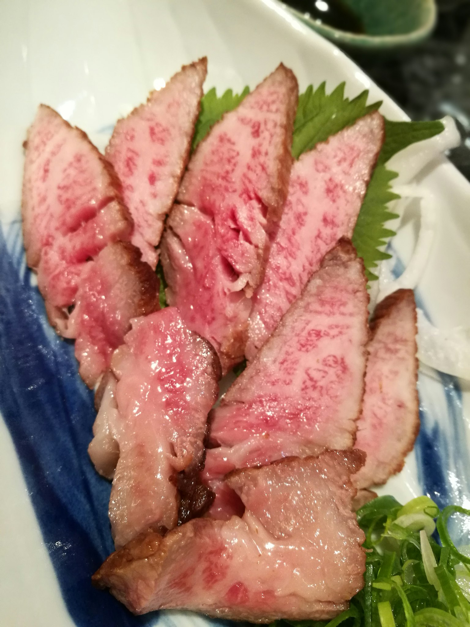 裝飾盤上擺放的和牛肉片和紫蘇葉