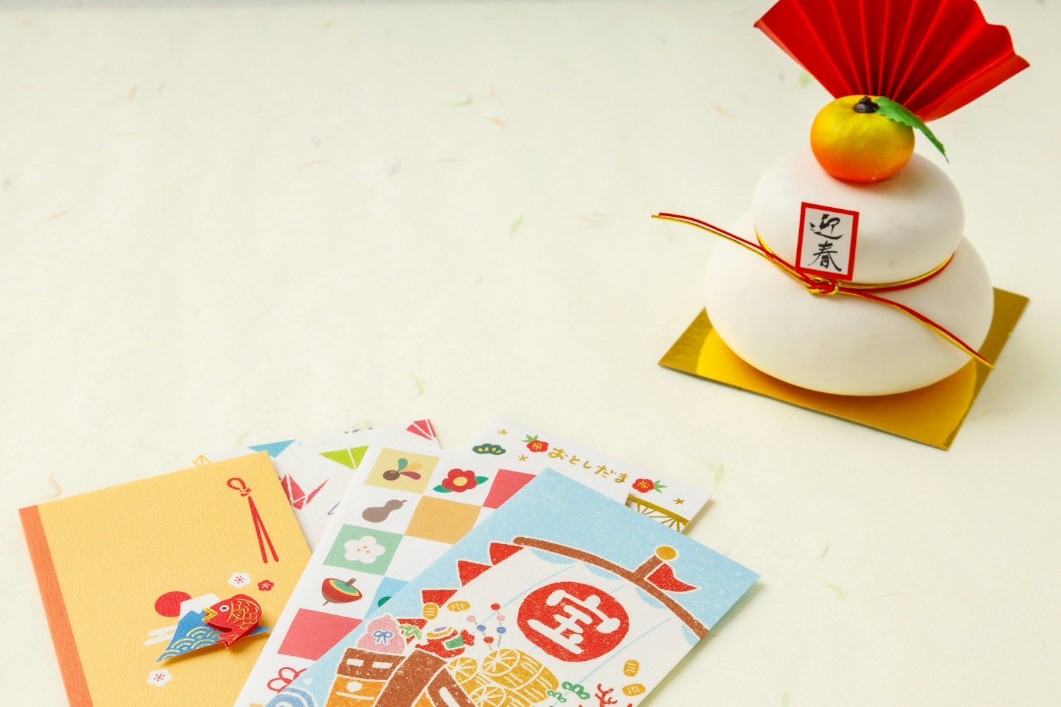 Trang trí năm mới với bánh gạo trắng có đồ trang trí đỏ và quýt ở trên cùng với những tấm thiệp đầy màu sắc