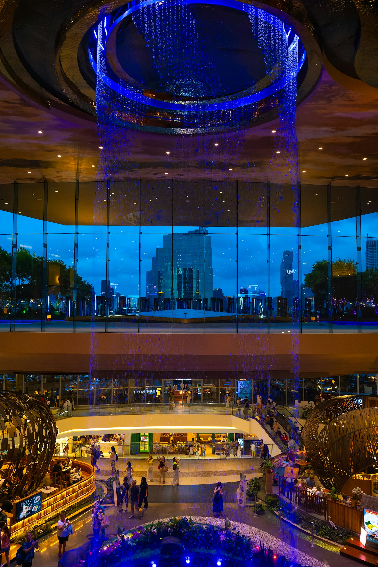 ภายในห้างสรรพสินค้าโมเดิร์นมีน้ำตกแสงสีฟ้าและเส้นขอบฟ้าของเมือง