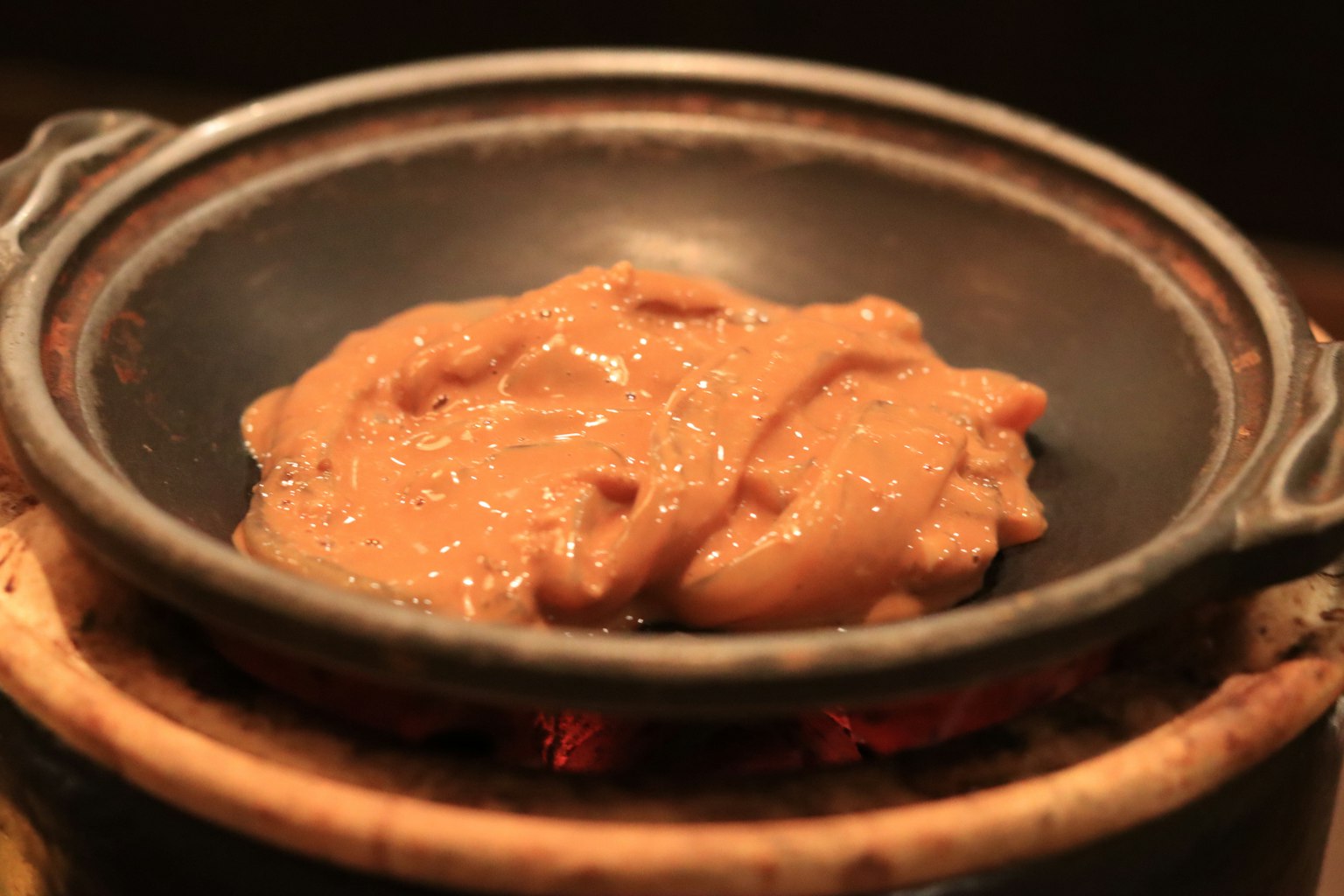 Hidangan yang dimasak dalam panci tanah liat di atas api