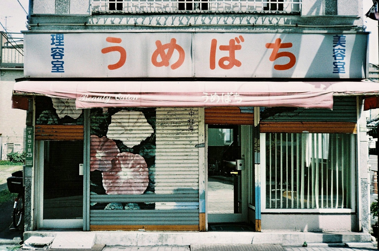 Esterno di un vecchio negozio giapponese con l'insegna 'うめばち'