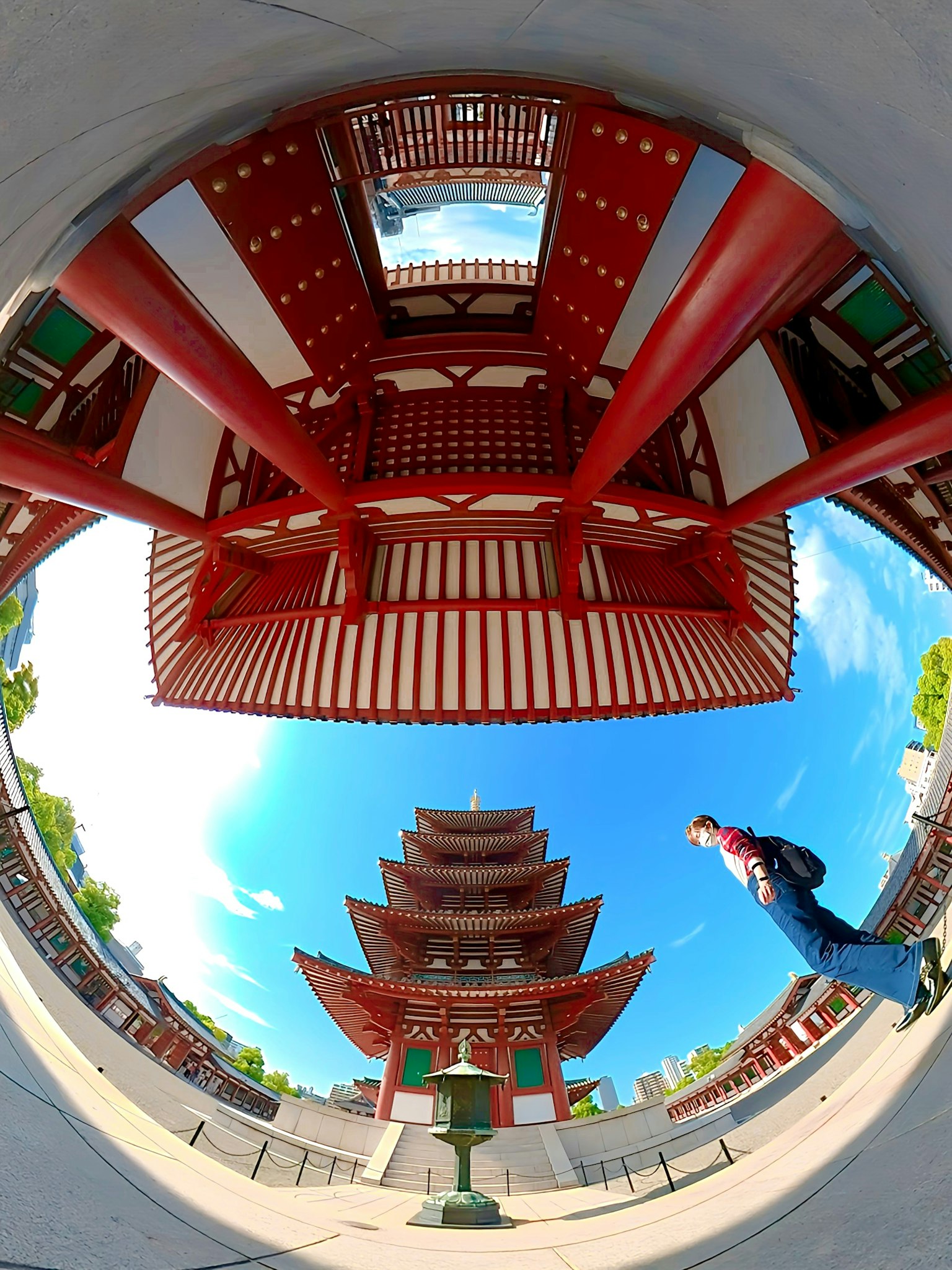 Architecture japonaise traditionnelle avec des couleurs rouge et blanche présentant une pagode et une personne marchant