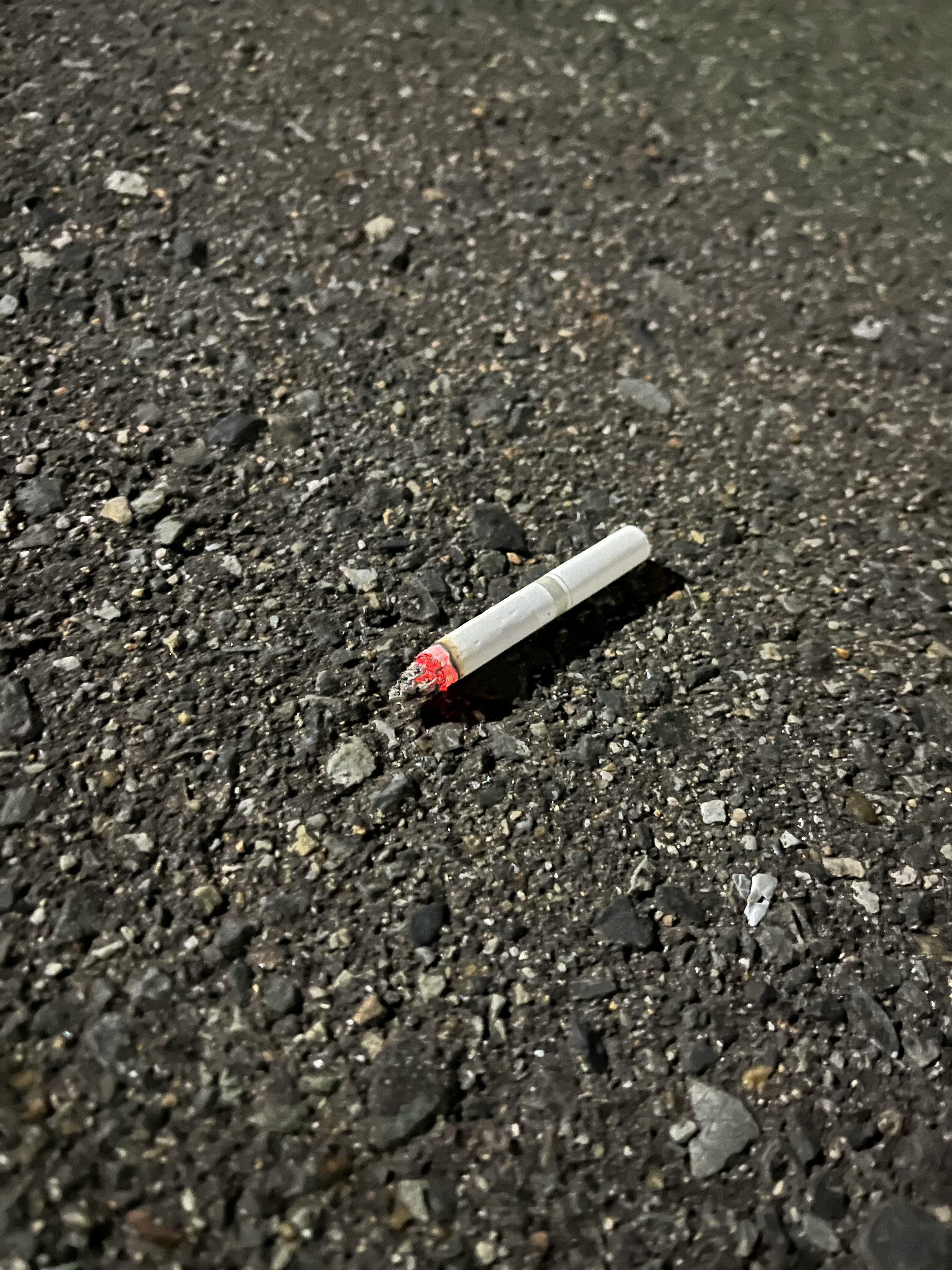 a cigarette butt on an asphalt road surface