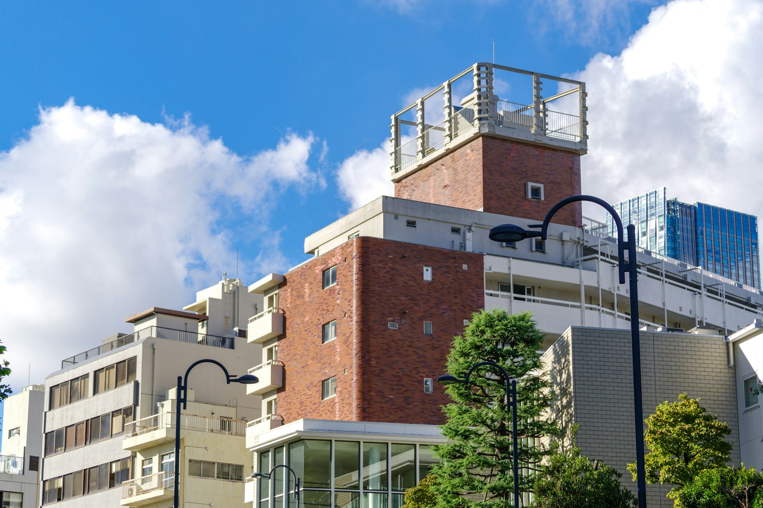 现代砖砌建筑在蓝天下和树木旁