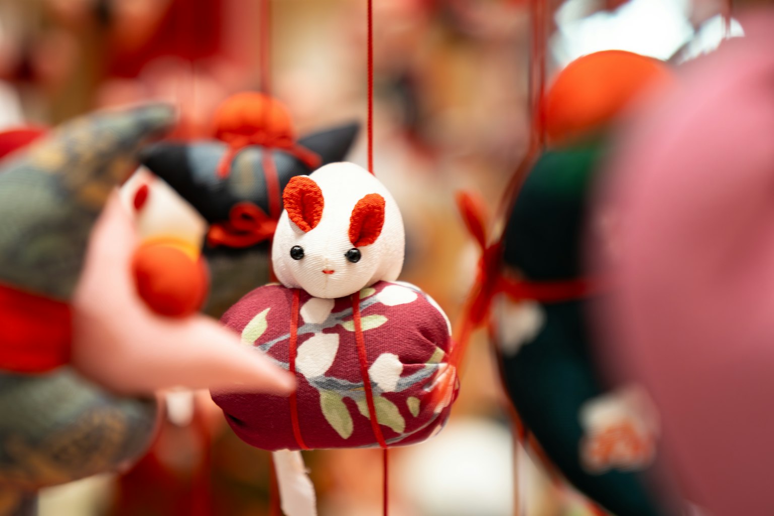 Adorno japonés tradicional con un pequeño animal blanco entre decoraciones rojas