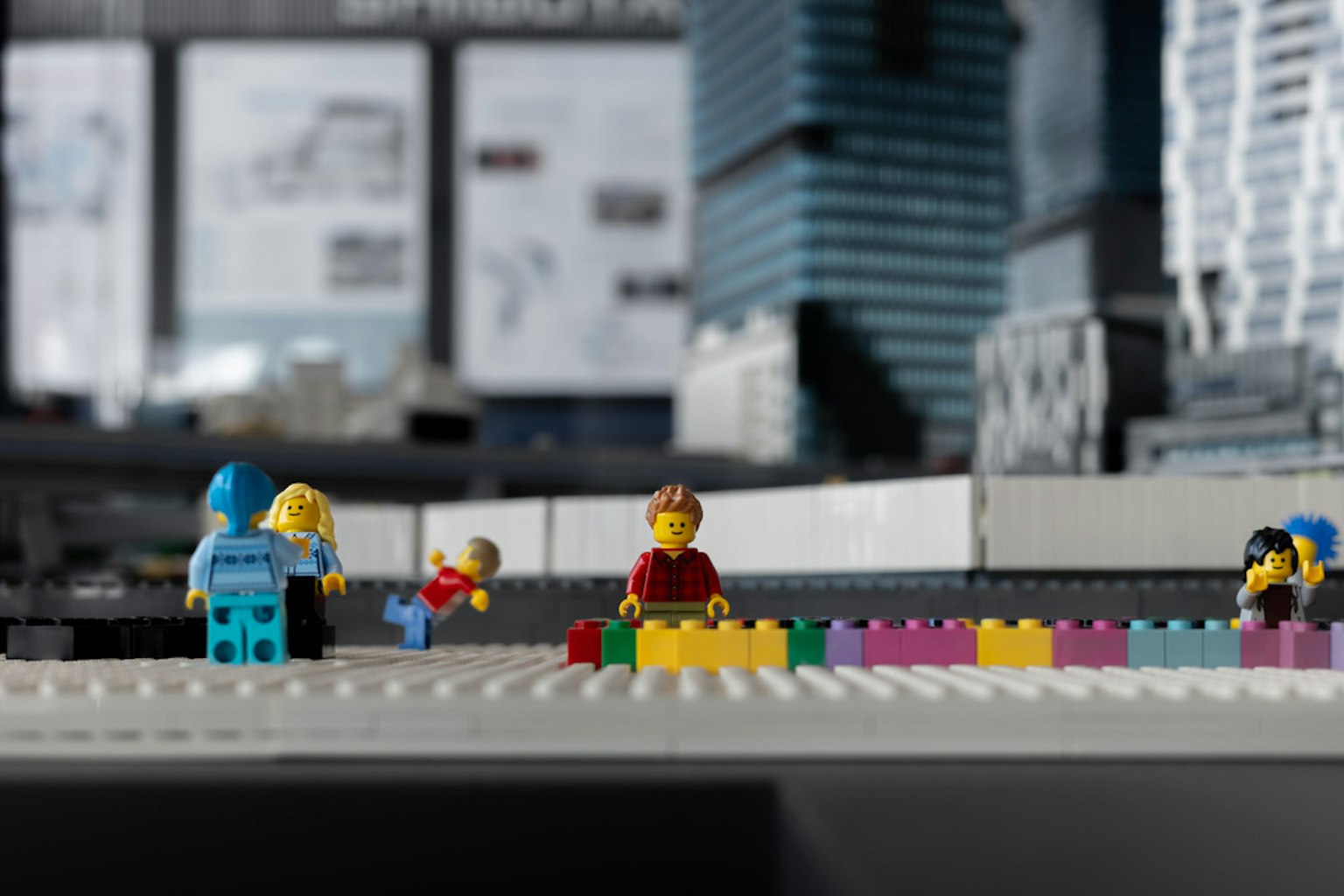 Szene mit LEGO-Minifiguren, die bunte Blöcke in einer Reihe anordnen