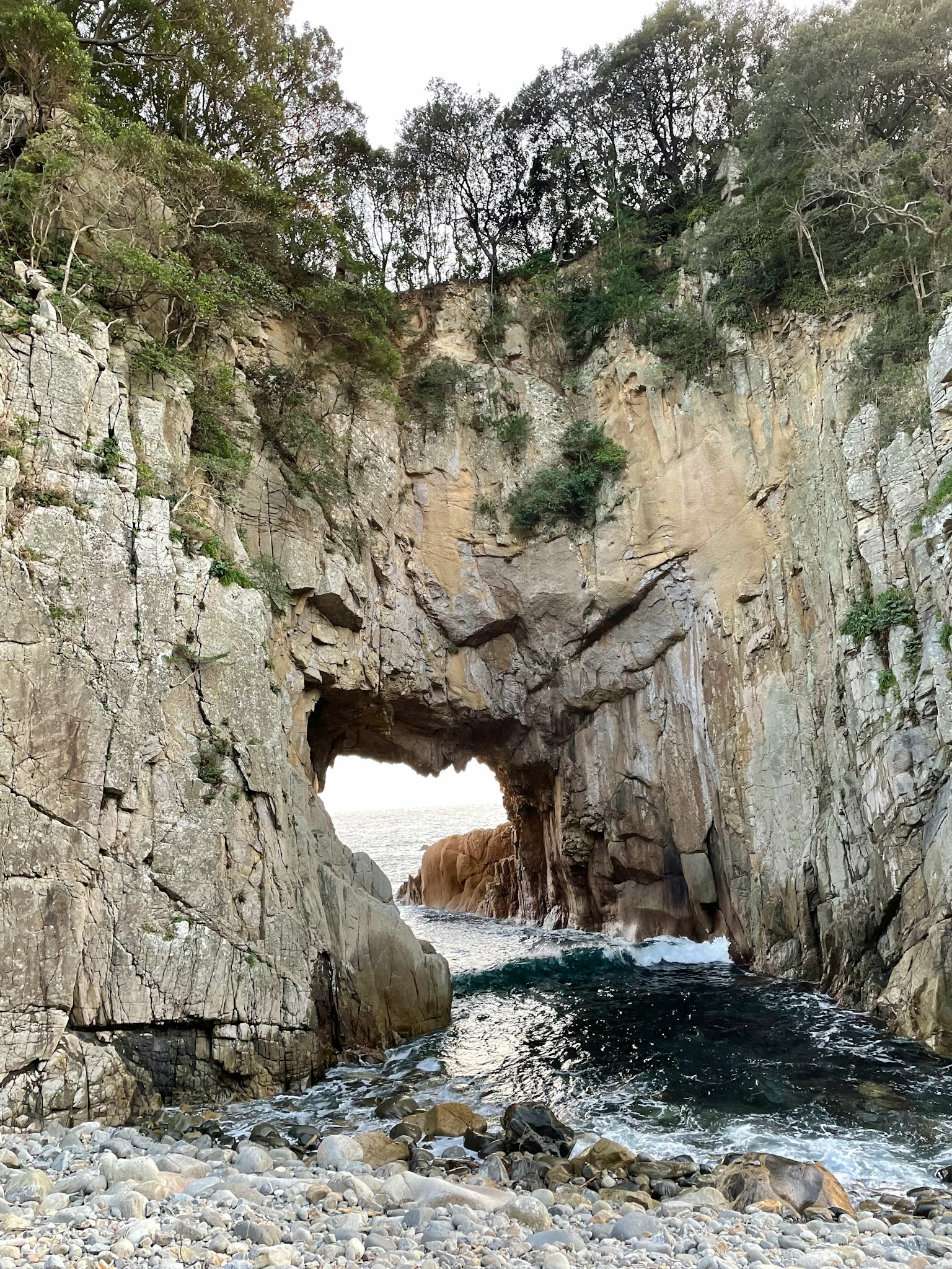 Rock formation with an arch and ocean waves crashing through