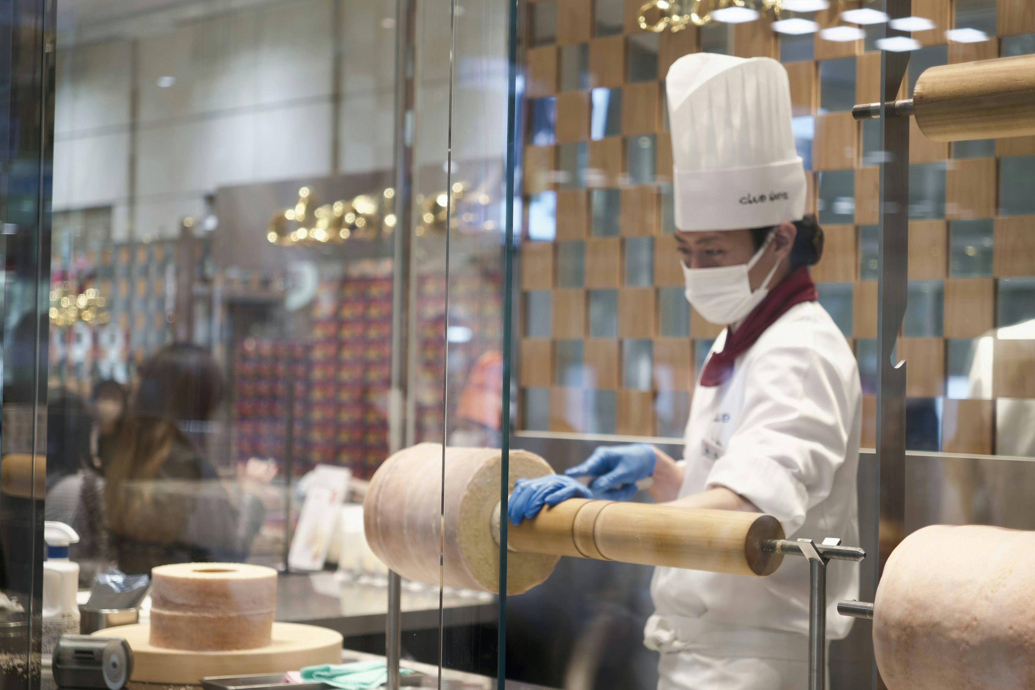 Un empleado talla con cuidado un Baumkuchen con forma de tocón