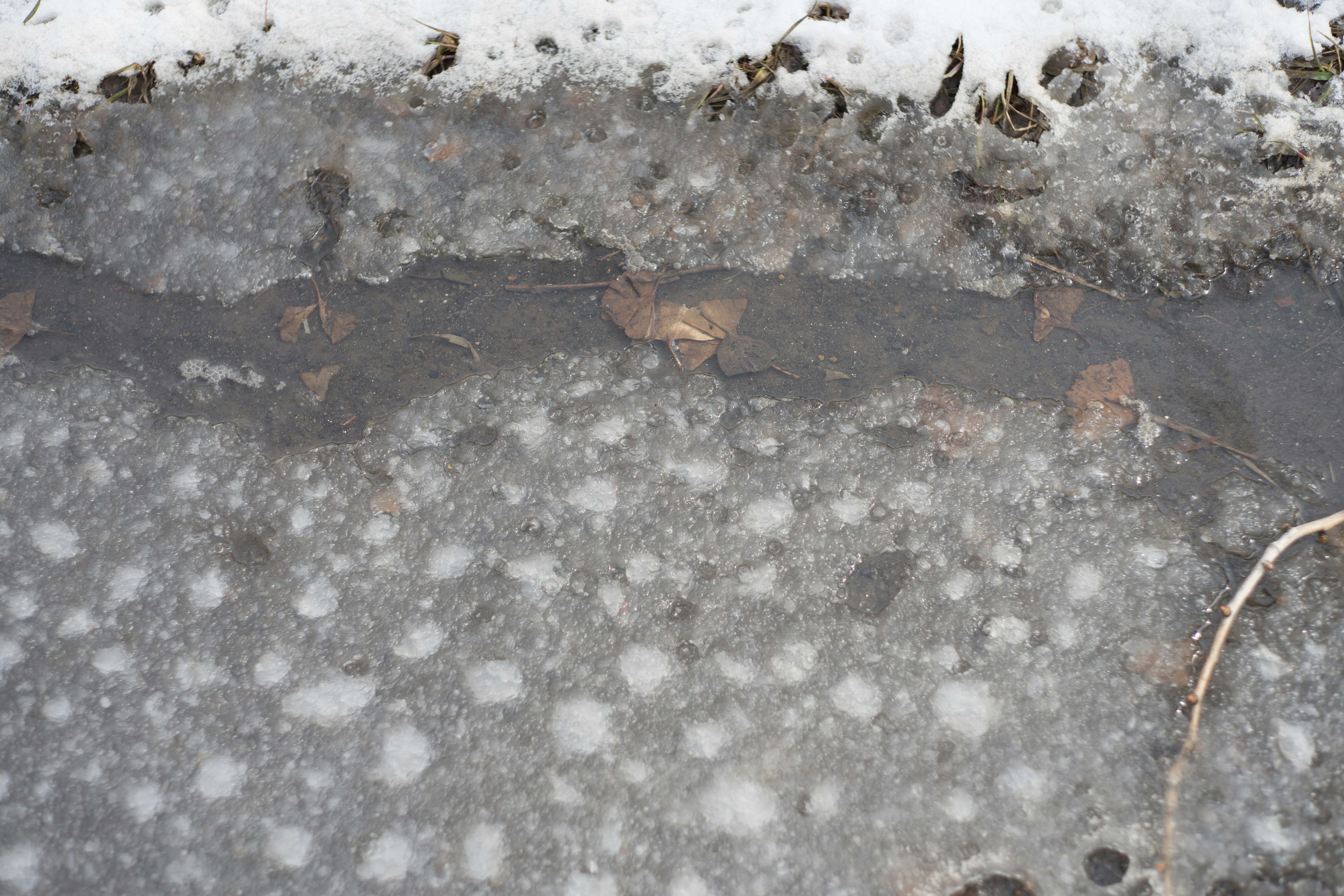 结冰路面上散落的雪粒与冰粒