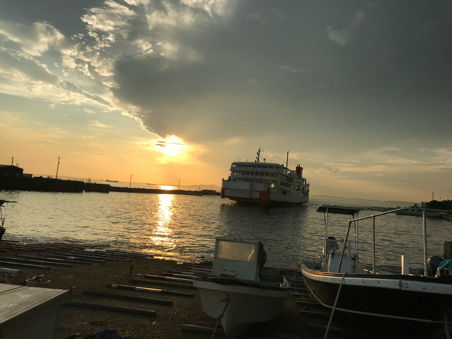 Un bateau amarré dans la mer reflétant le coucher de soleil