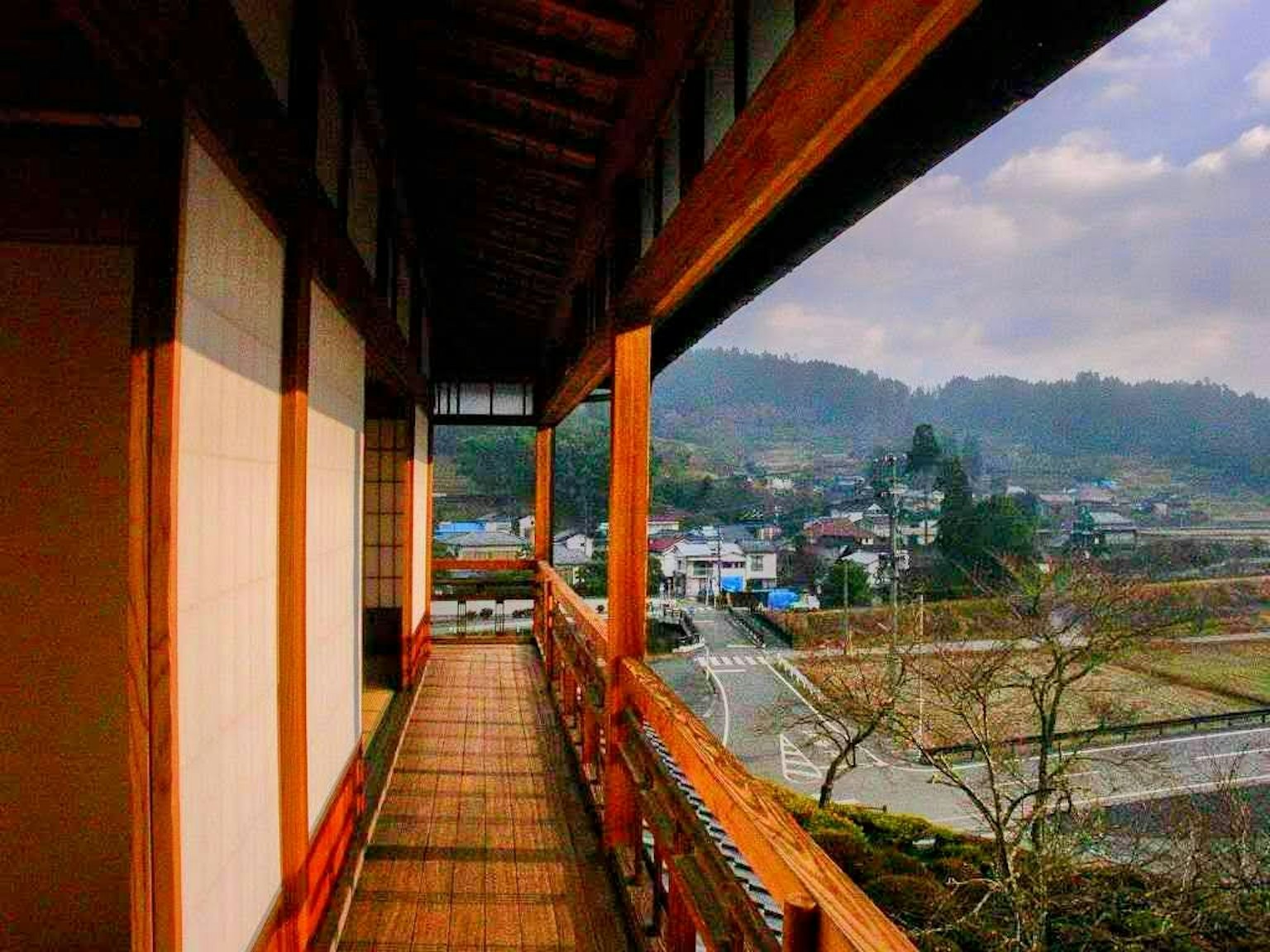 Traditional wooden corridor overlooking a beautiful mountainous landscape in Japan