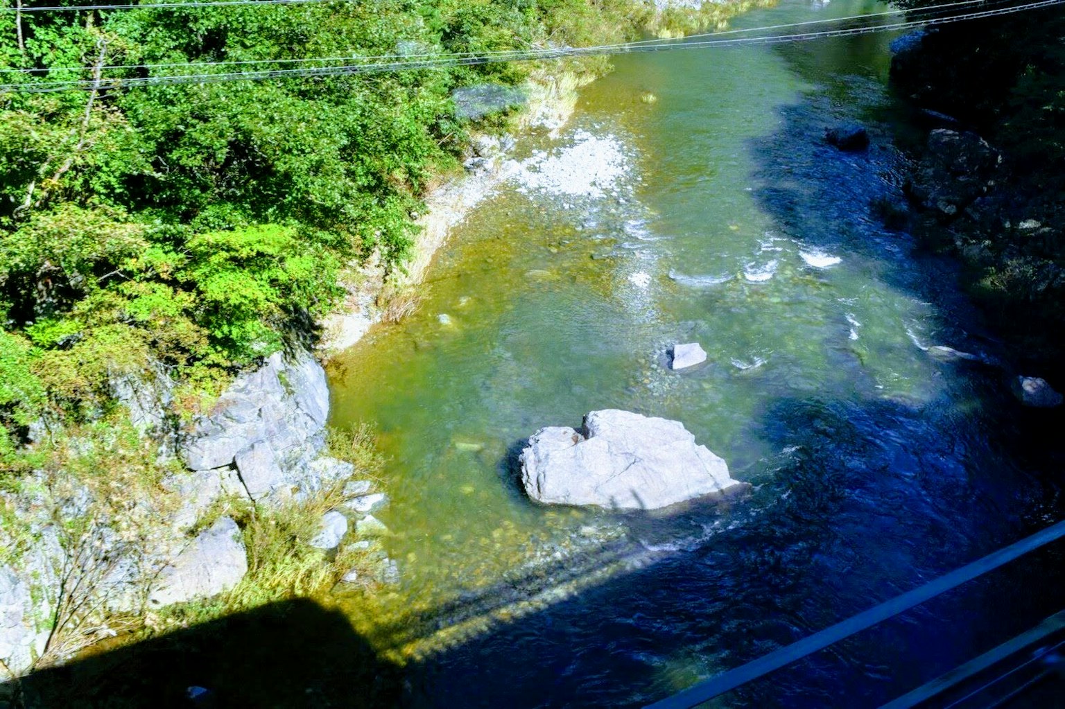 Malersiche Aussicht auf einen Fluss, umgeben von Grün und Felsen