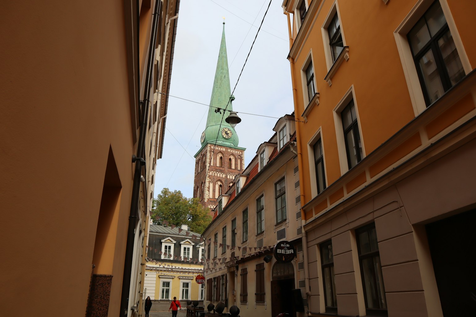 Vue d'une rue étroite avec une église à flèche verte