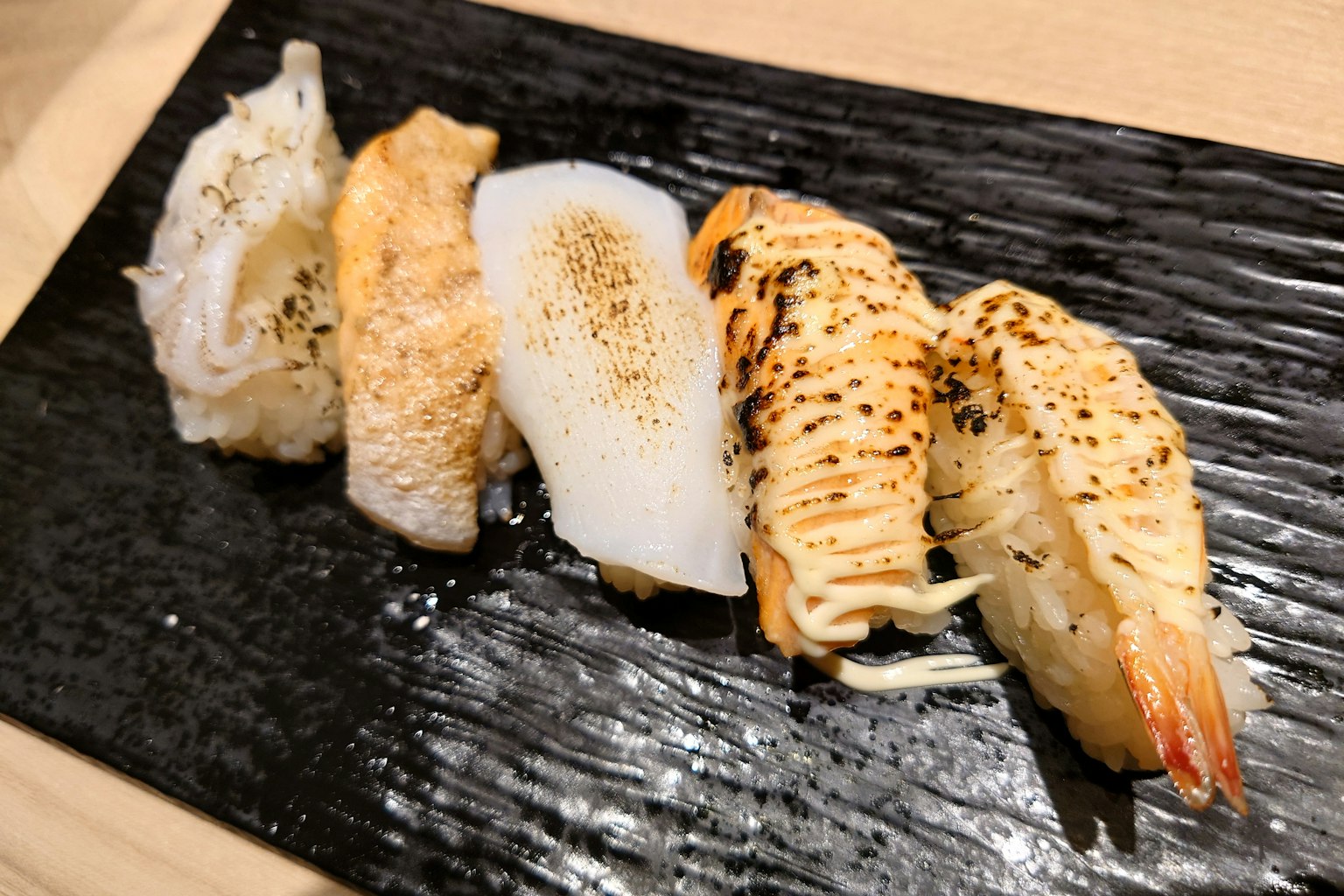 ซูชิย่างหลากหลายชนิดบนจานดำ