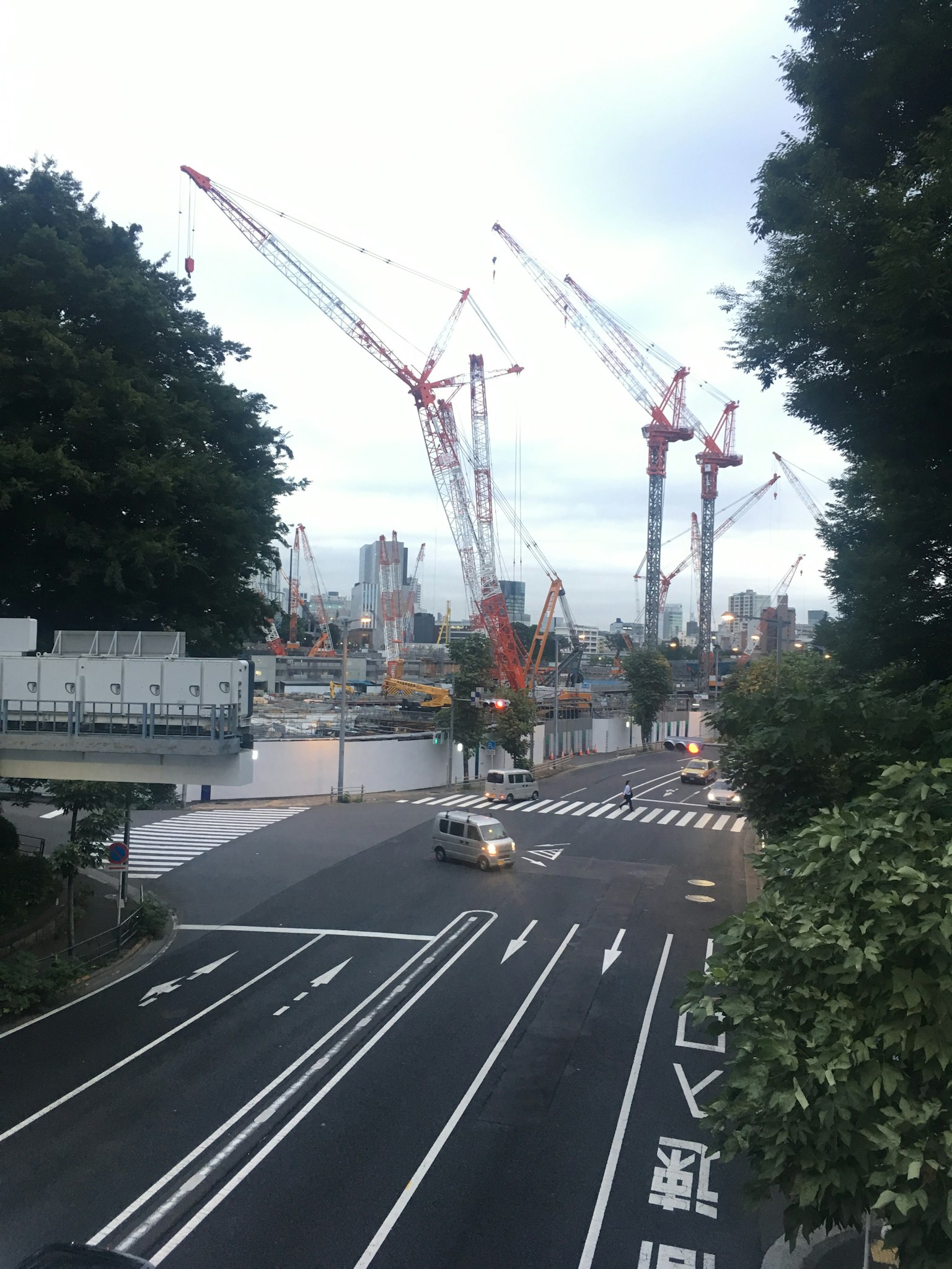 Gru di costruzione che sovrastano una strada cittadina
