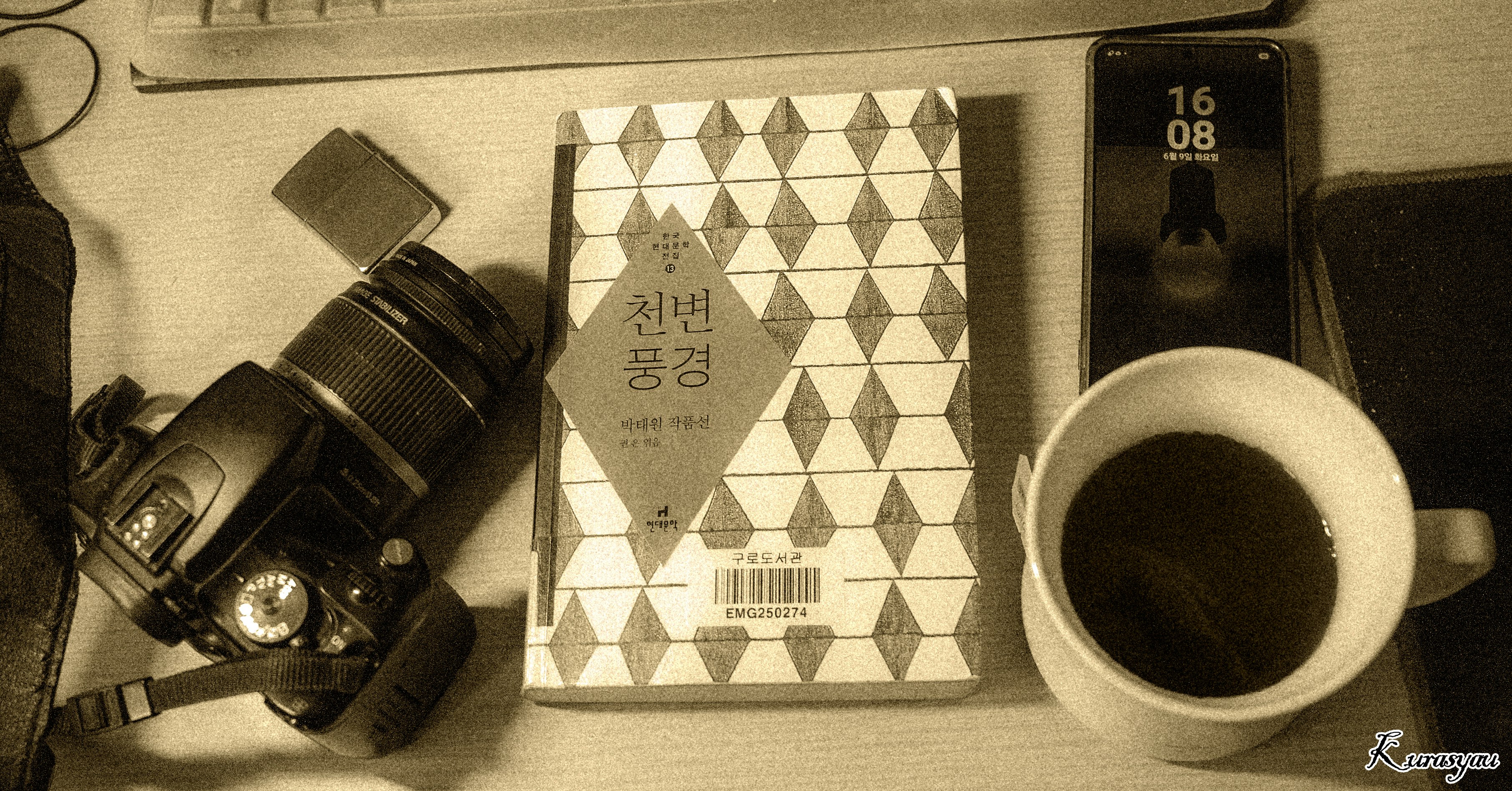 カメラとコーヒー、書籍が並ぶデスクの静物
