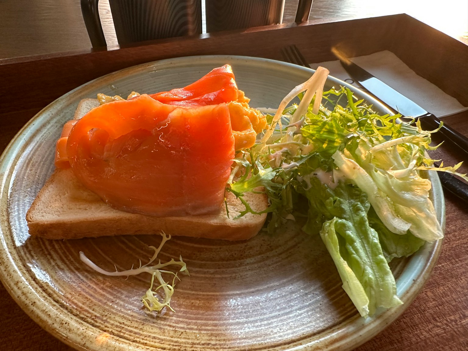 Bánh mì nướng với cá hồi xông khói và salad bên cạnh