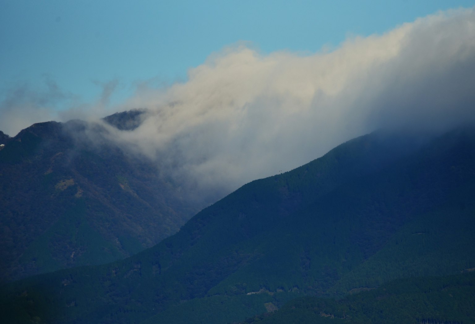 Berge teilweise von Wolken bedeckt vor einem blauen Himmel