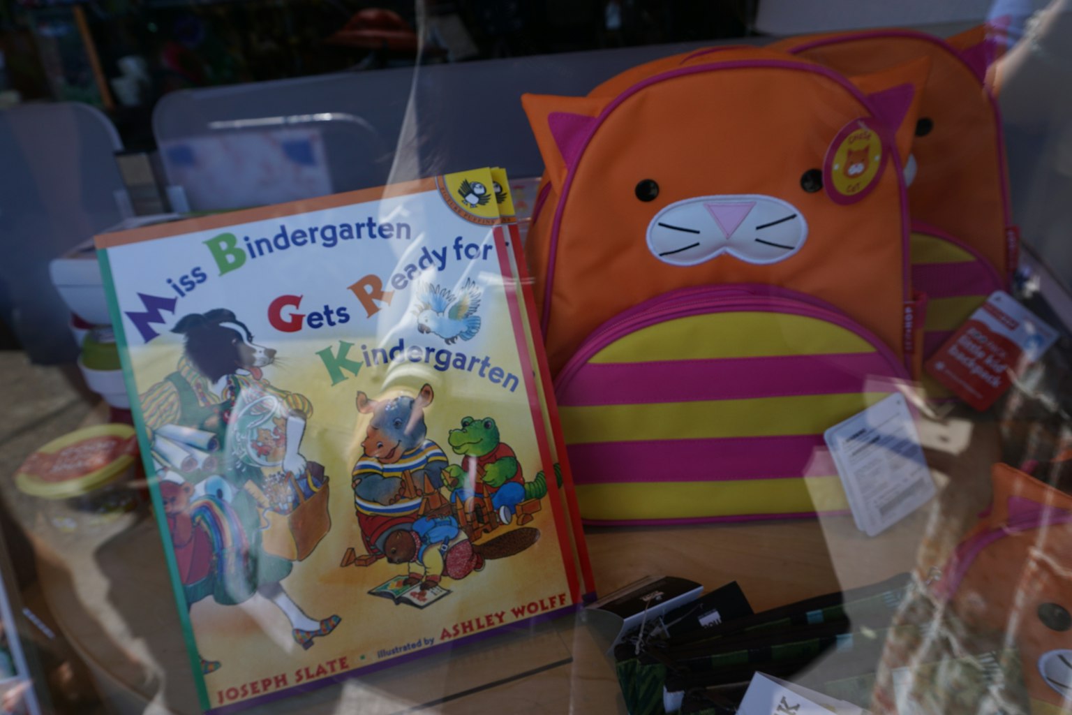 色彩繽紛的貓背包和兒童書籍展示在商店櫥窗中