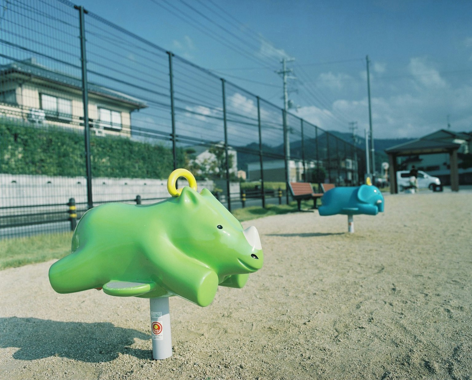 Spring riders in the shape of animals in a playground with green and blue colors