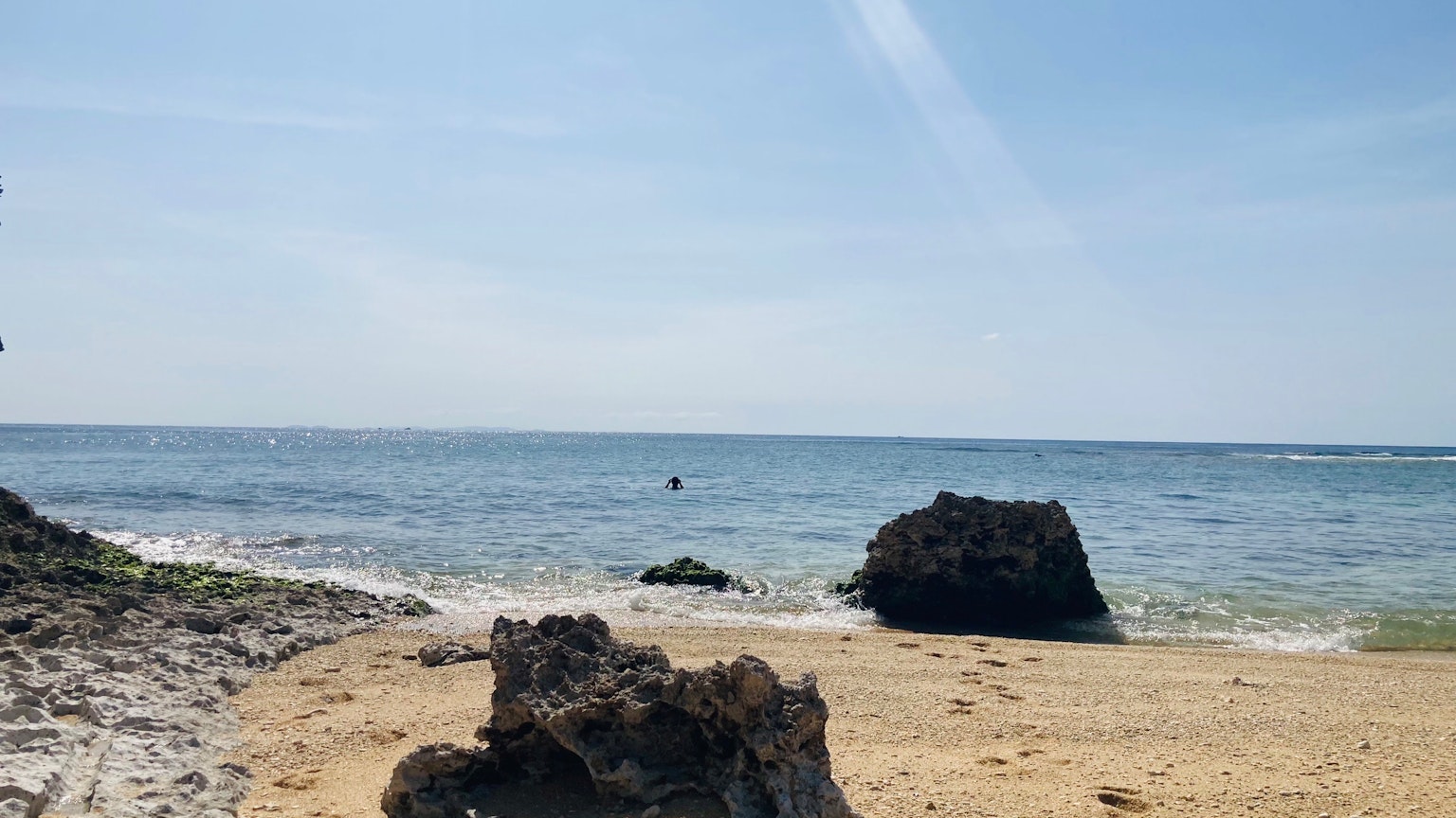 海灘場景，藍天和海洋，岩石和沙灘