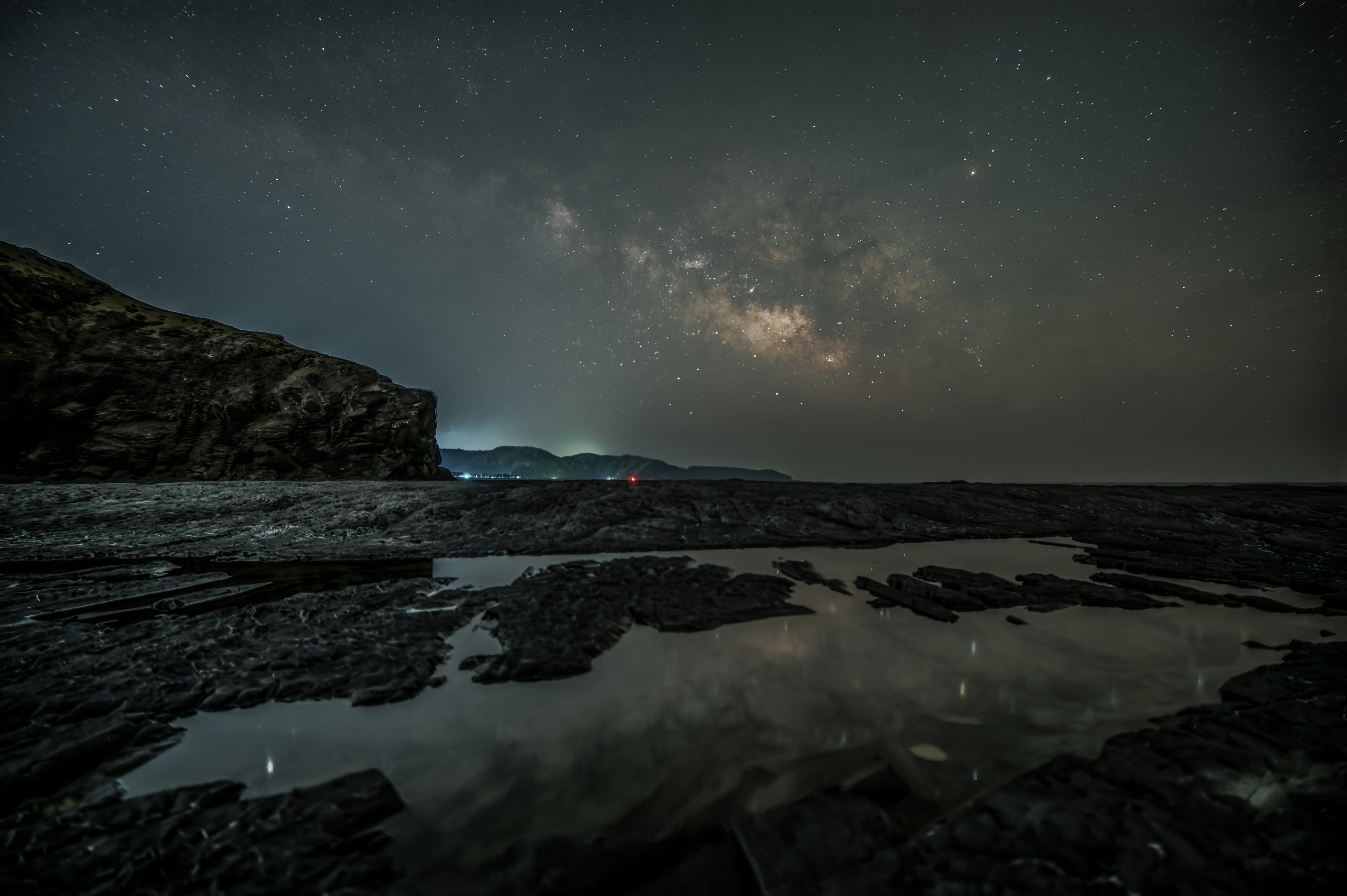 夜の海岸で広がる天の川のような星空