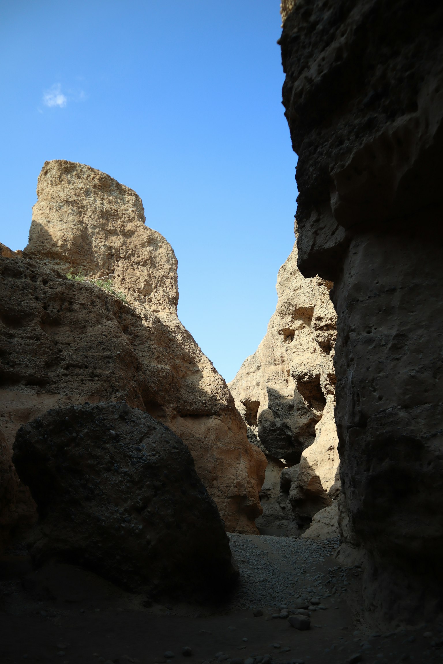 Schmaler Canyon umgeben von felsigen Klippen mit klarem blauen Himmel