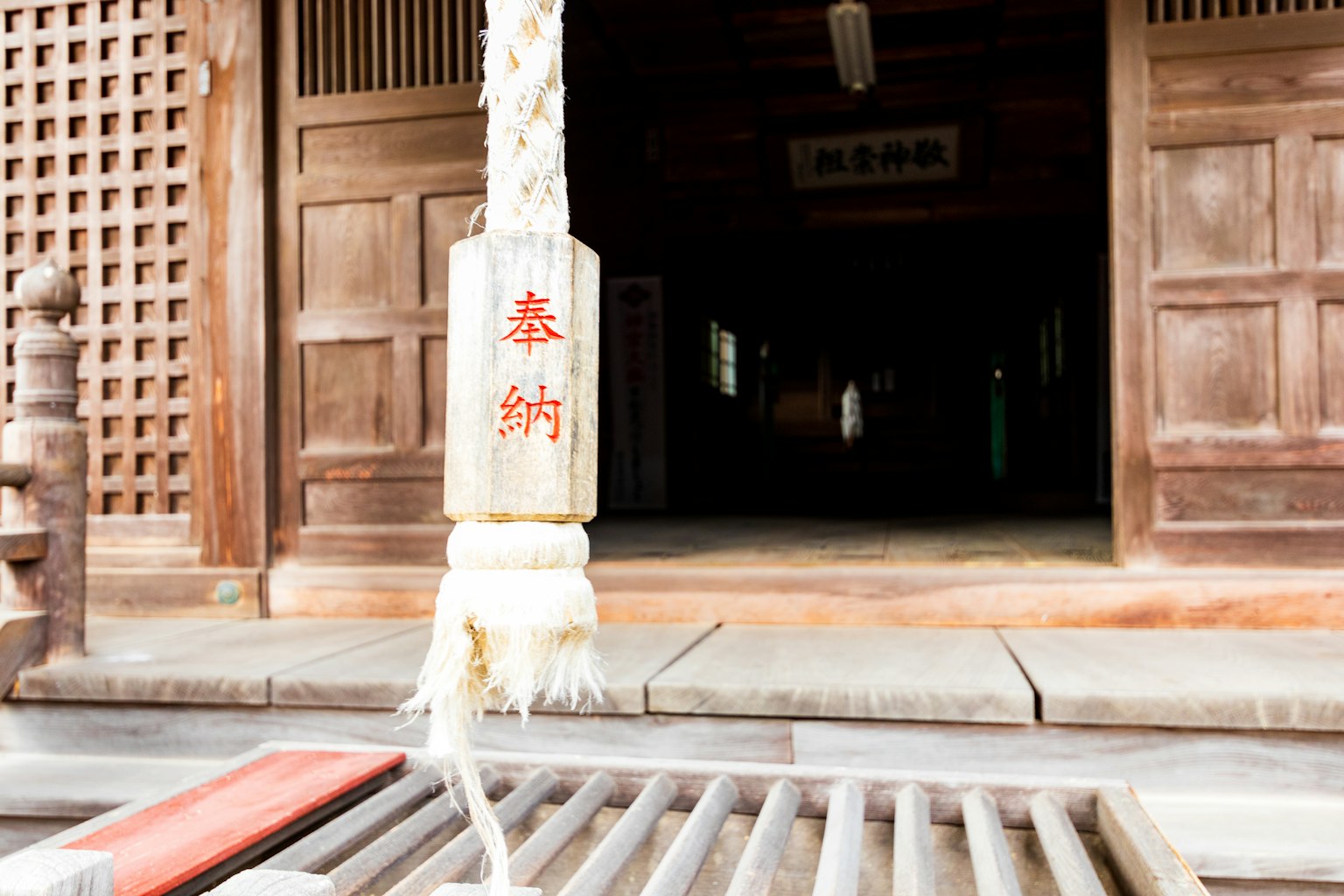 Entrée d'un bâtiment en bois avec une corde et des caractères chinois